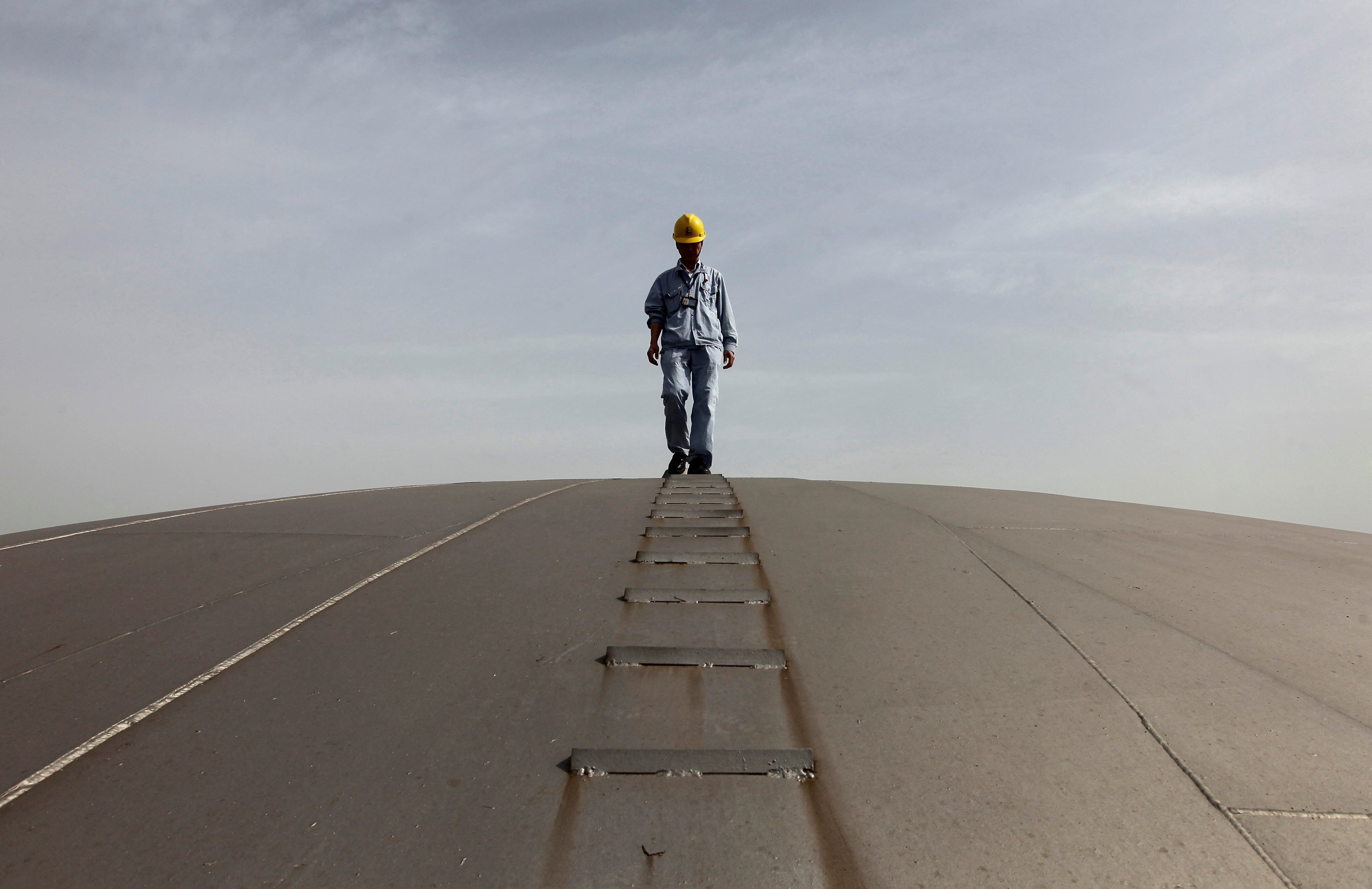 An employee walks on top of an oil tank at a Sinopec refinery in Wuhan in this file photo from April 2012. The refiner says it will pay 80 per cent of its 2021 profits to shareholders through dividend. Photo: Reuters