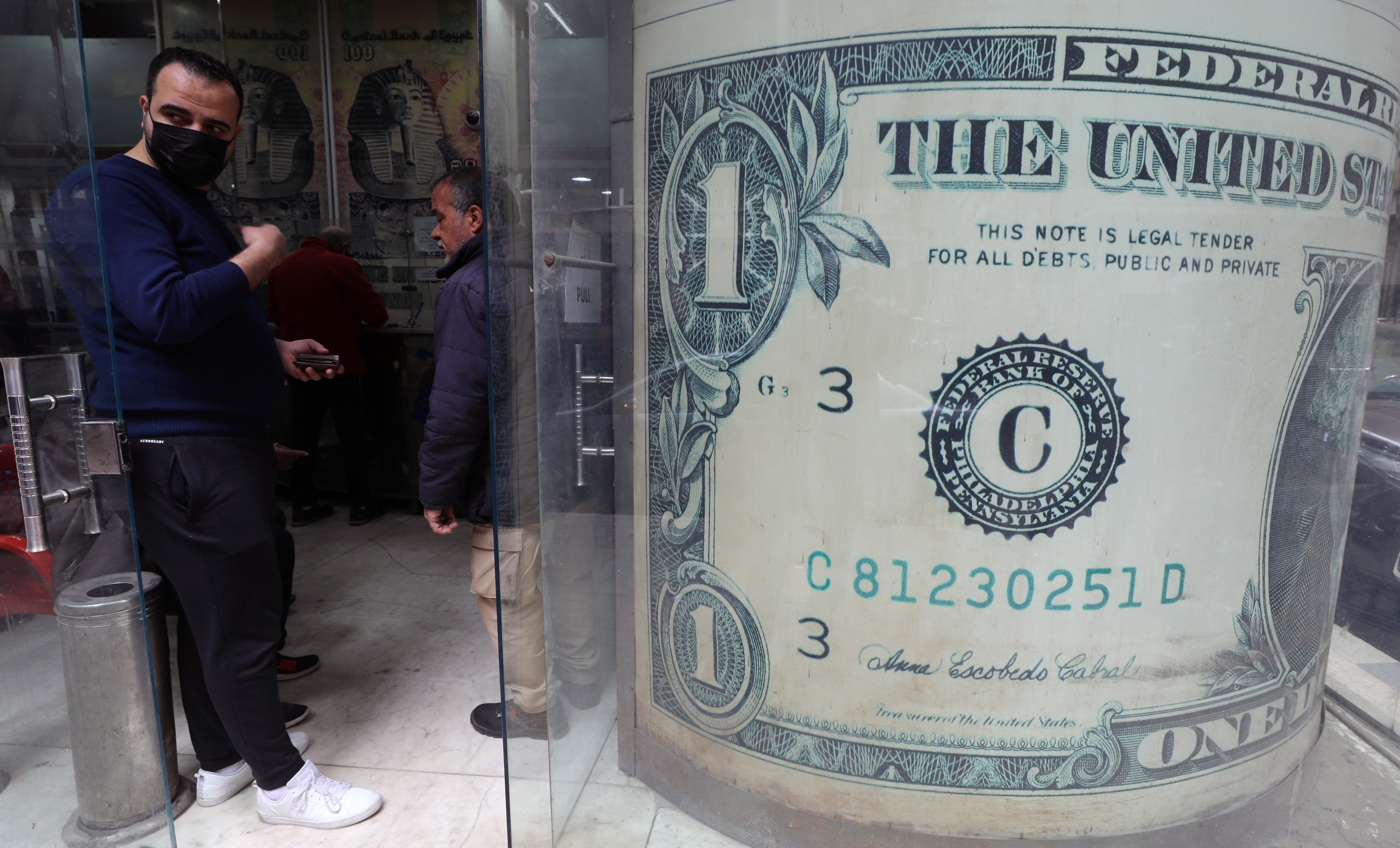 Egyptians wait at a currency exchange office in Cairo on March 22. The US dollar continues to serve a valued purpose as a freely exchangeable currency recognised in practically every country. Photo: EPA-EFE