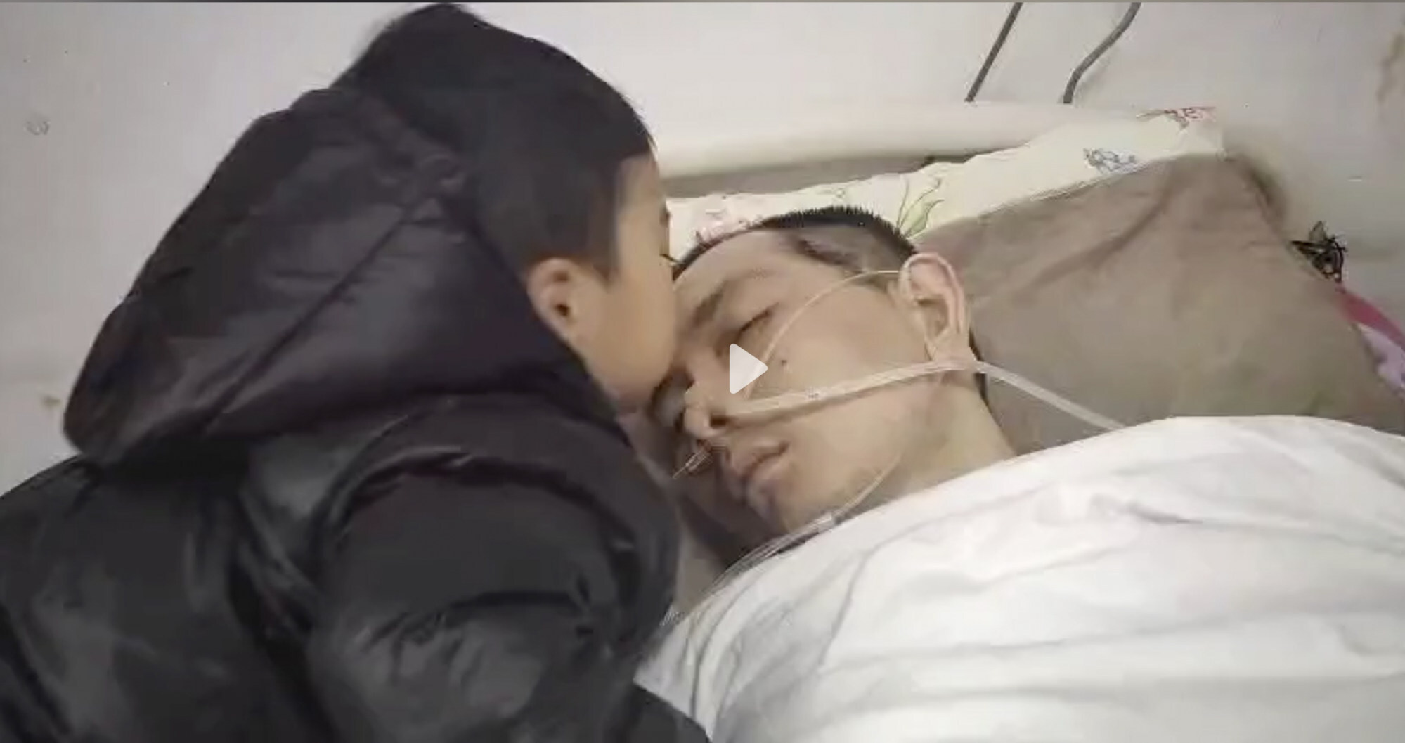 Tutu, a three-year-old boy, kisses his father, who suffered from a brain haemorrhage. Photo: Douyin
