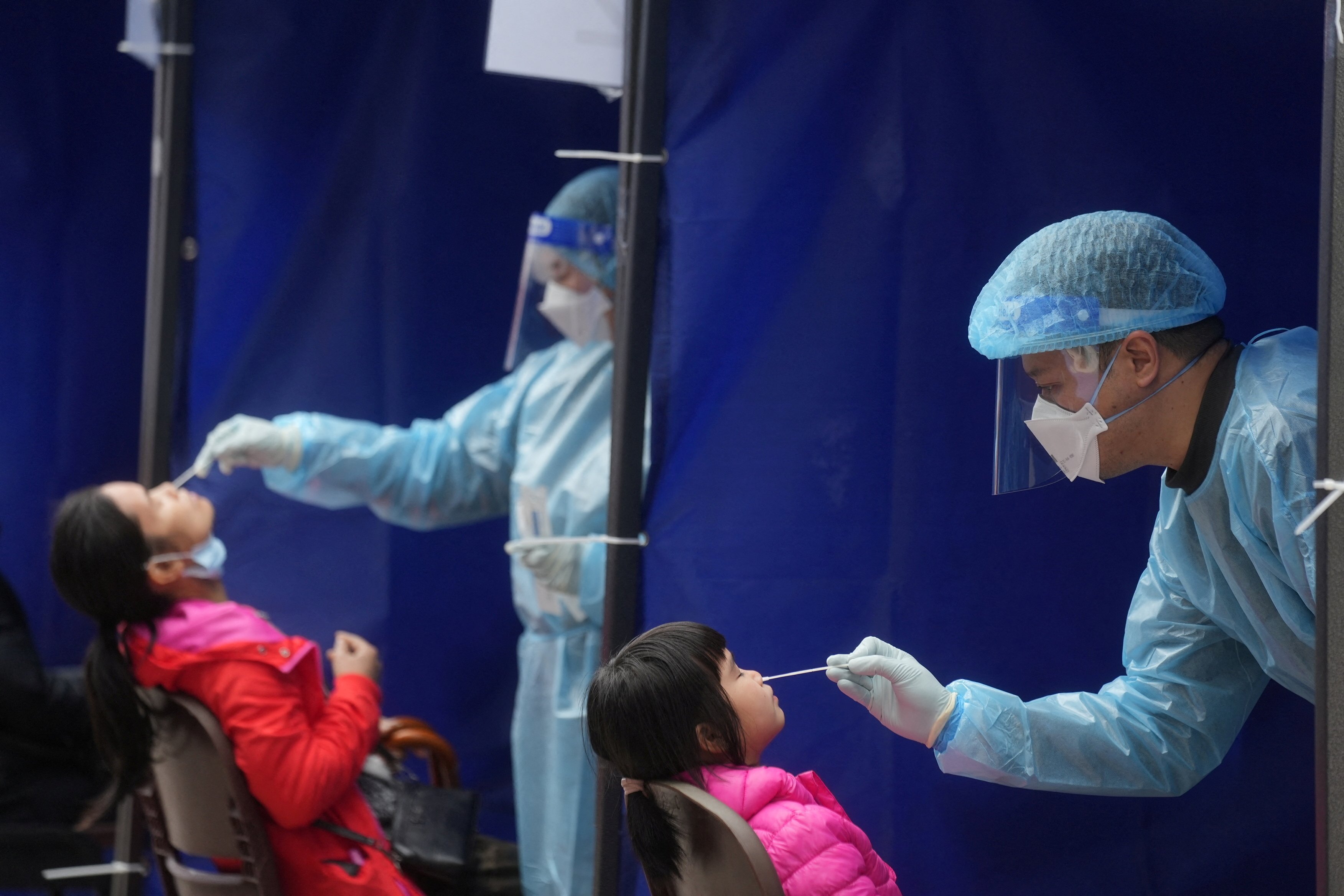 Medical workers take swab samples from residents at a Covid-19 testing site in Hong Kong’s Sha Tin neighbourhood last month. Photo: Reuters