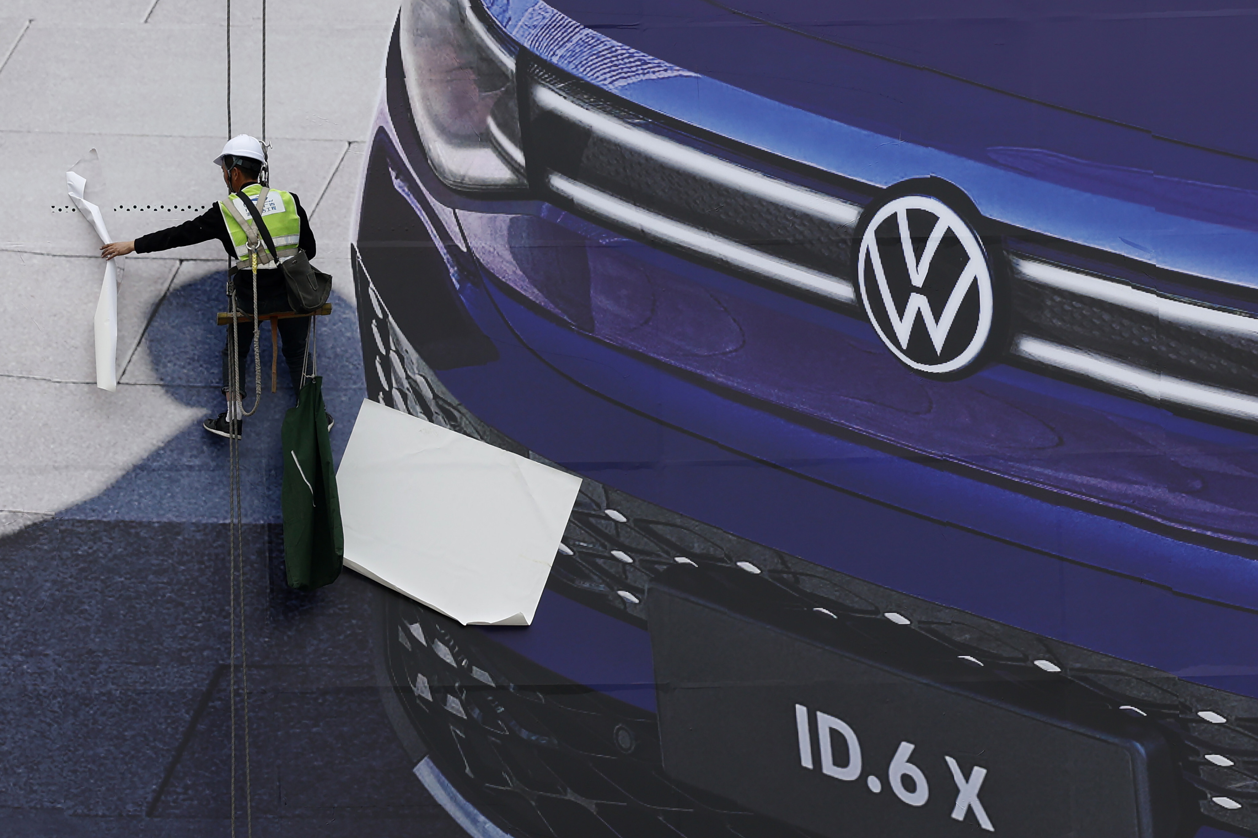 A worker prepares a giant VW billboard ahead of the Auto Shanghai 2021 show in this file photo. Photo: AP