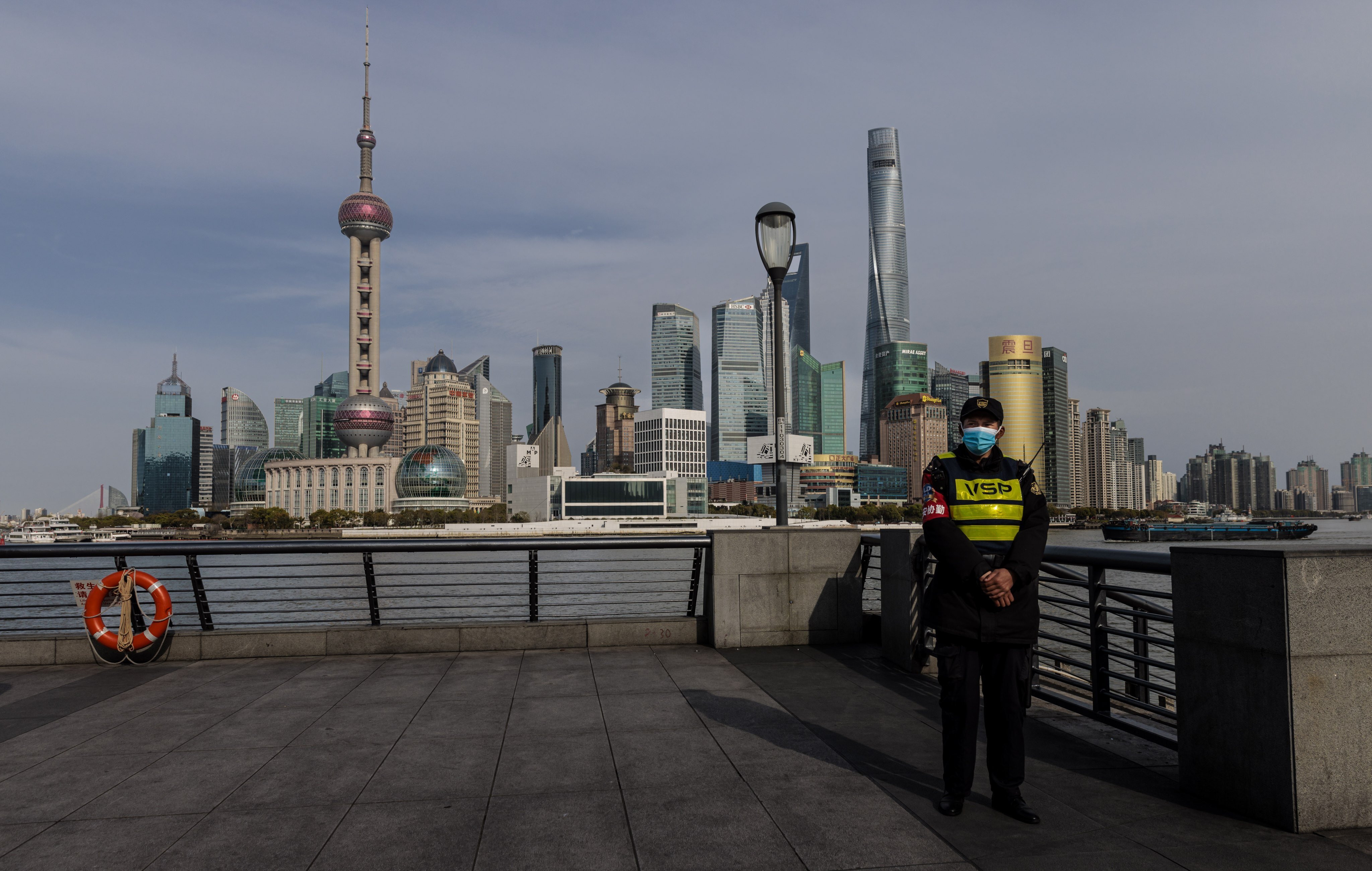 A police officer stands guard on the Bund with Pudong’s main financial district in the background in Shanghai on March 28. Photo: EPA-EFE