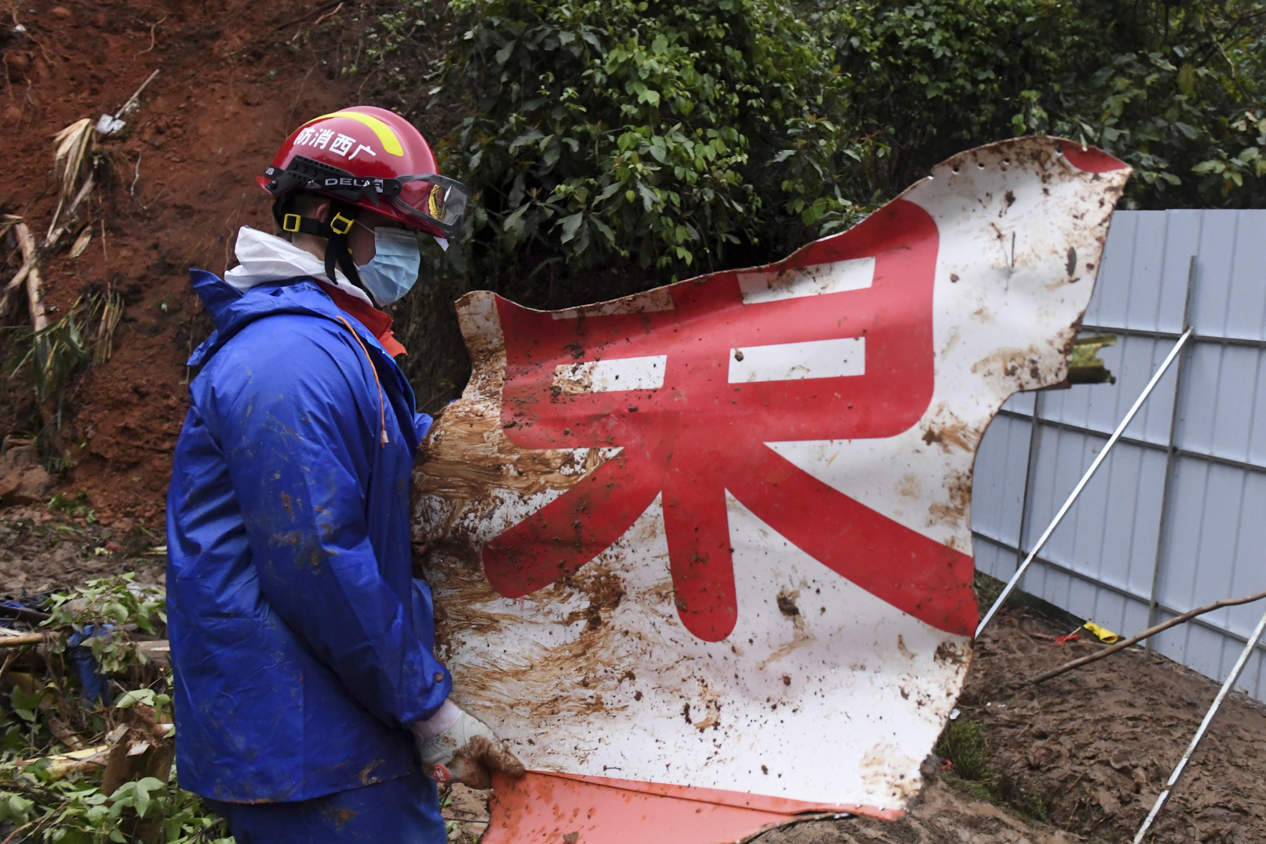 A rescue worker with a piece of debris at the plane’s crash site in southern China’s Guangxi Zhuang autonomous region. Photo: AP