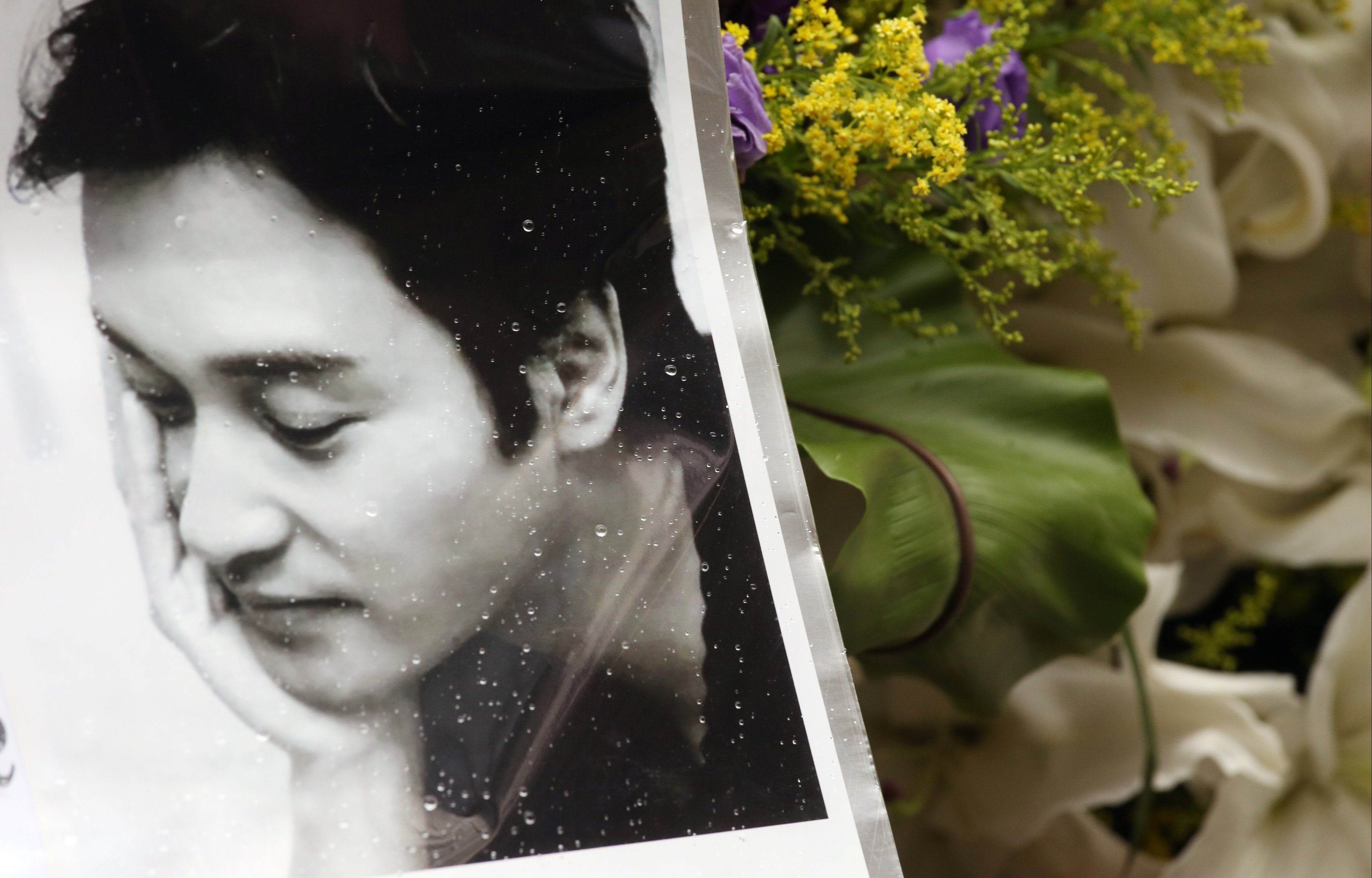 Fans of late Canto-pop singer Leslie Cheung offer wreaths outside the Mandarin Oriental hotel in Central, Hong Kong on the anniversary of his death on April 1, 2014. Photo: K. Y. Cheng