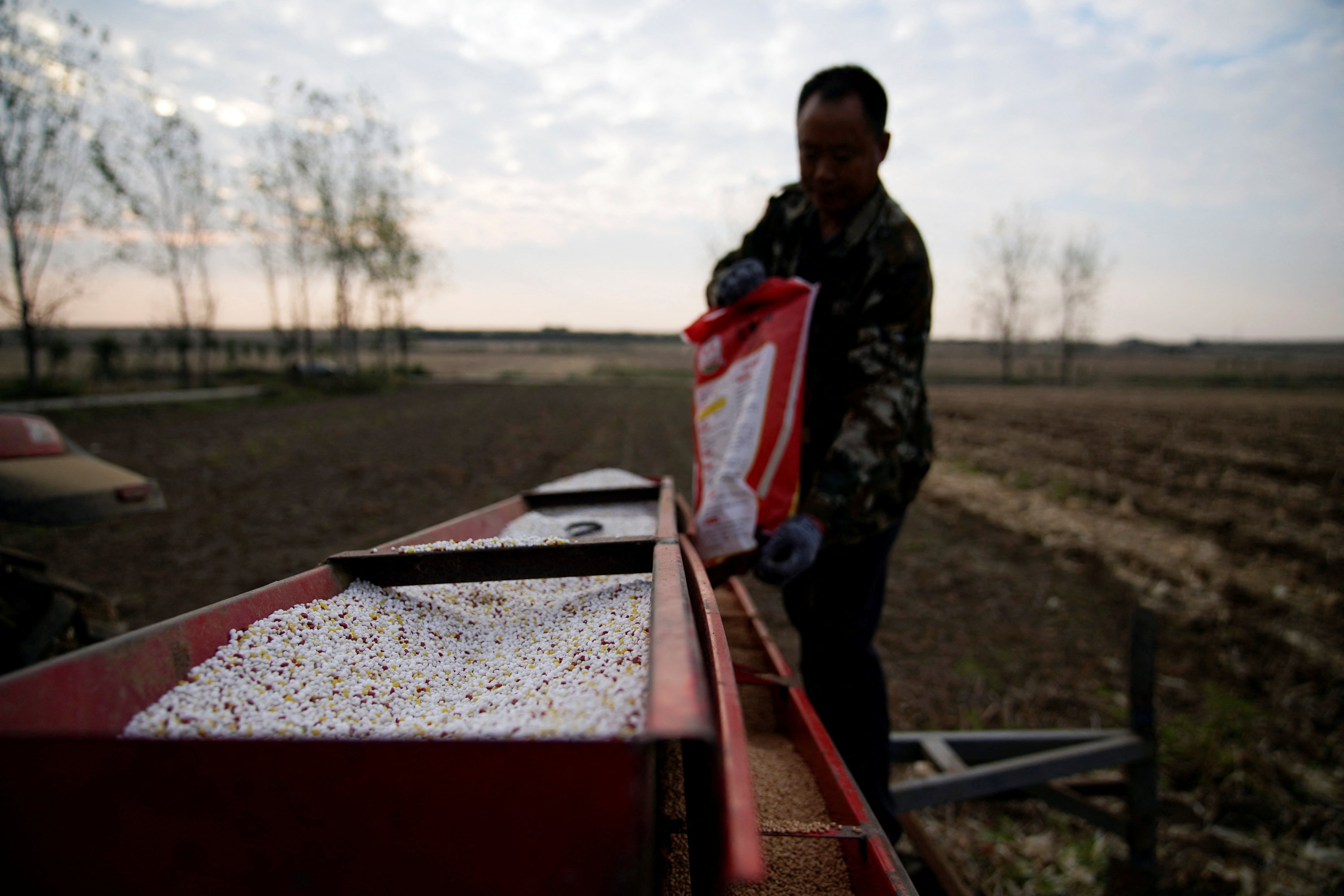 A farmer loads fertiliser and seeds into a seeder in Nanyang, Henan province. Photo: Reuters