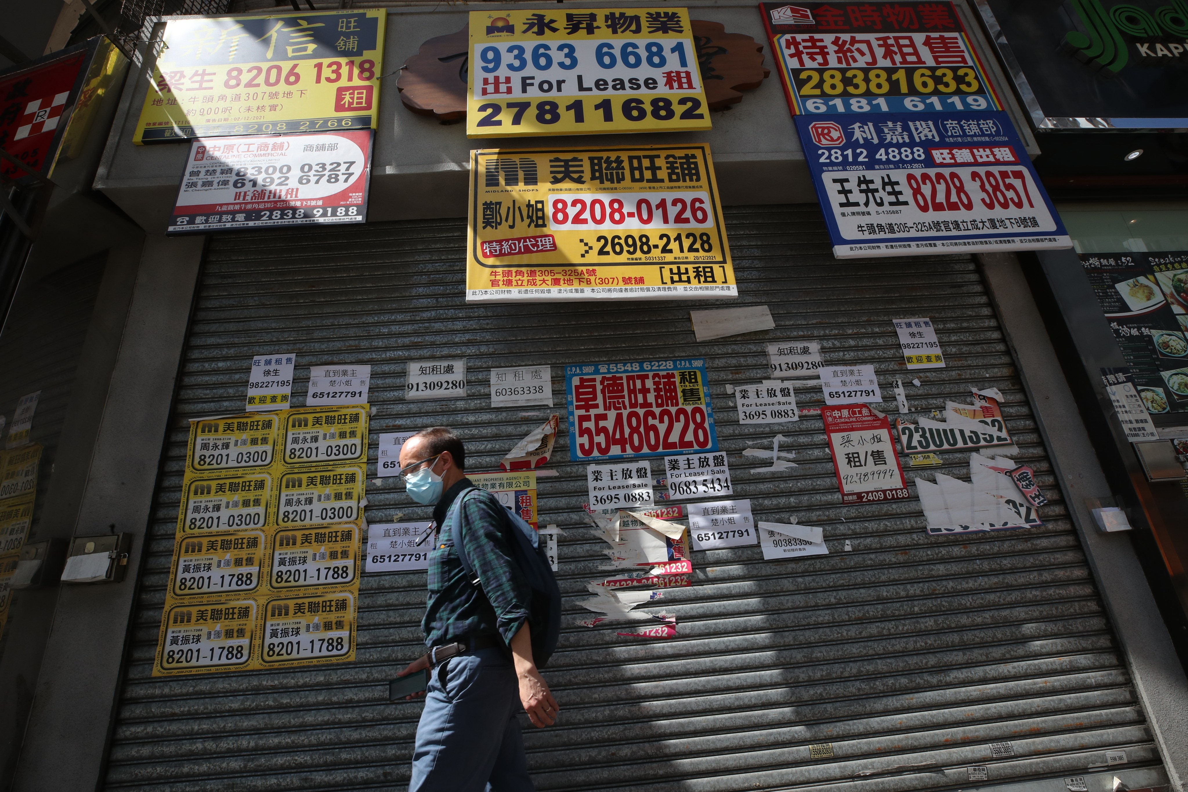 A pedestrian walks past closed retail shops in Kwun Tong on March 31. The retail sector is among the hardest-hit as businesses across Hong Kong struggle to survive amid the city’s many pandemic restrictions. Photo: Edmond So