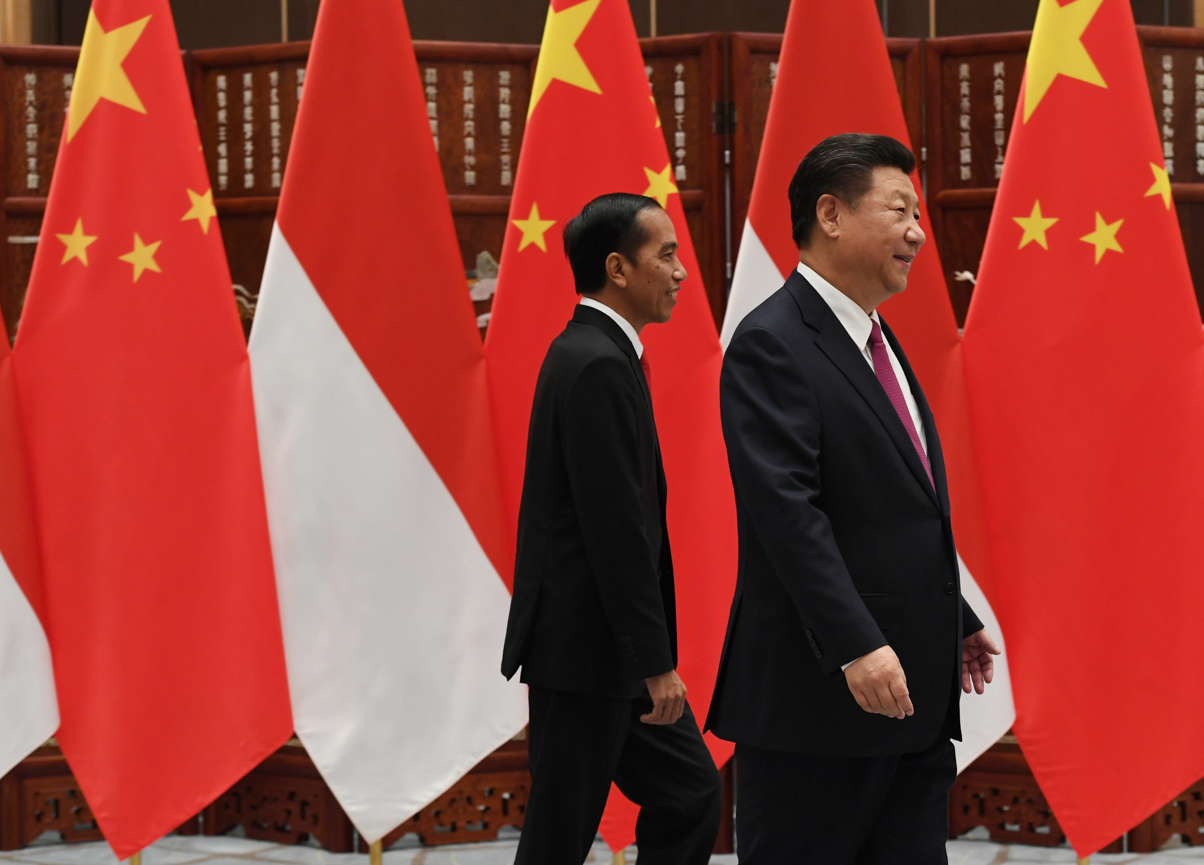 Chinese President Xi Jinping and Indonesian President Joko Widodo walk together at a meeting in 2016. Photo: AP