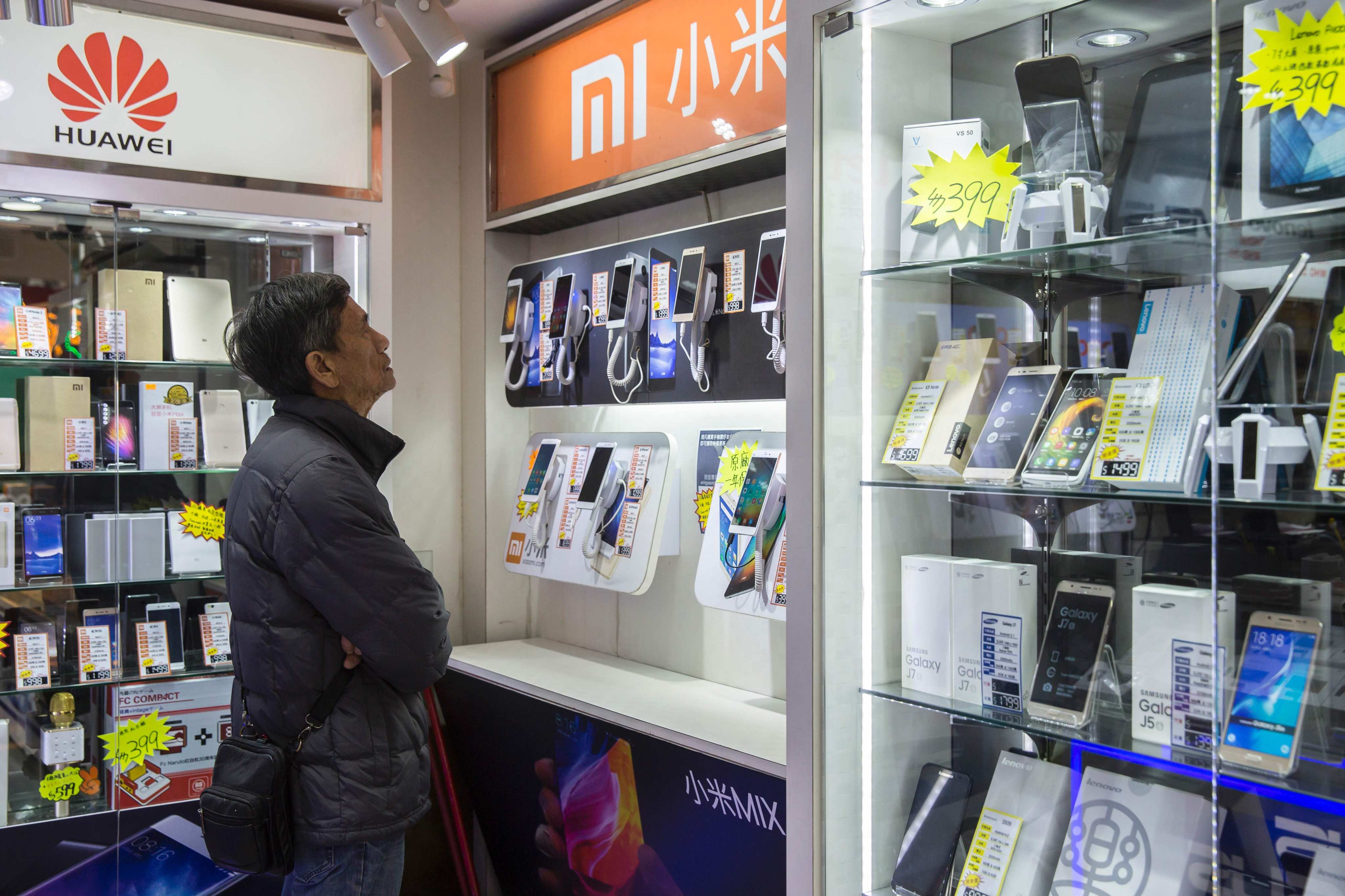 A customer browses mobile phones in a retail store in the Sham Shui Po district of Hong Kong. Electronic waste has become an increasing problem in China, which is expected to have 6 billion discarded mobile phones by 2025. Photo: AFP