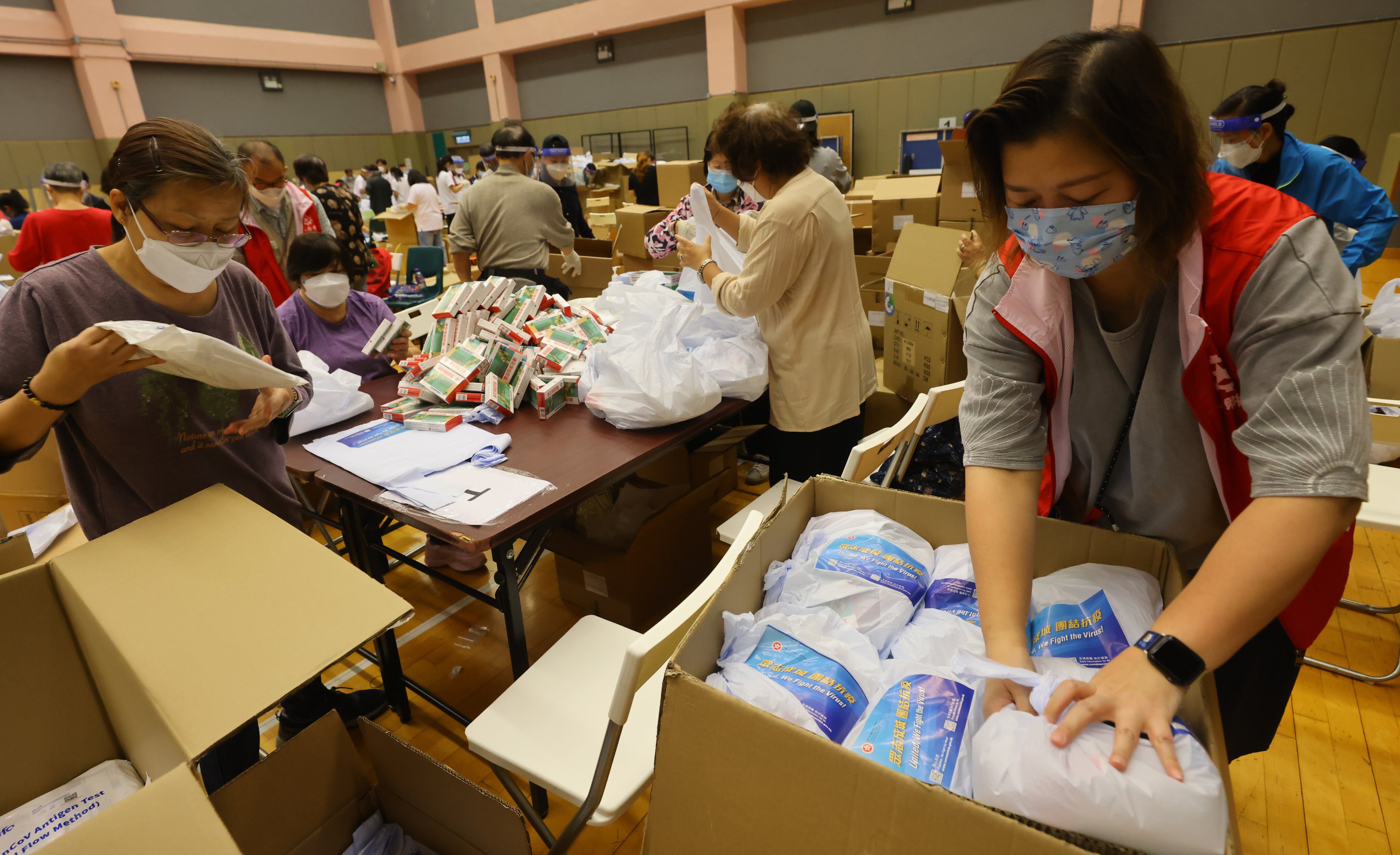 Volunteers pack anti-epidemic supply kits to be used in a mass at-home testing exercise later this week. Photo: Dickson Lee