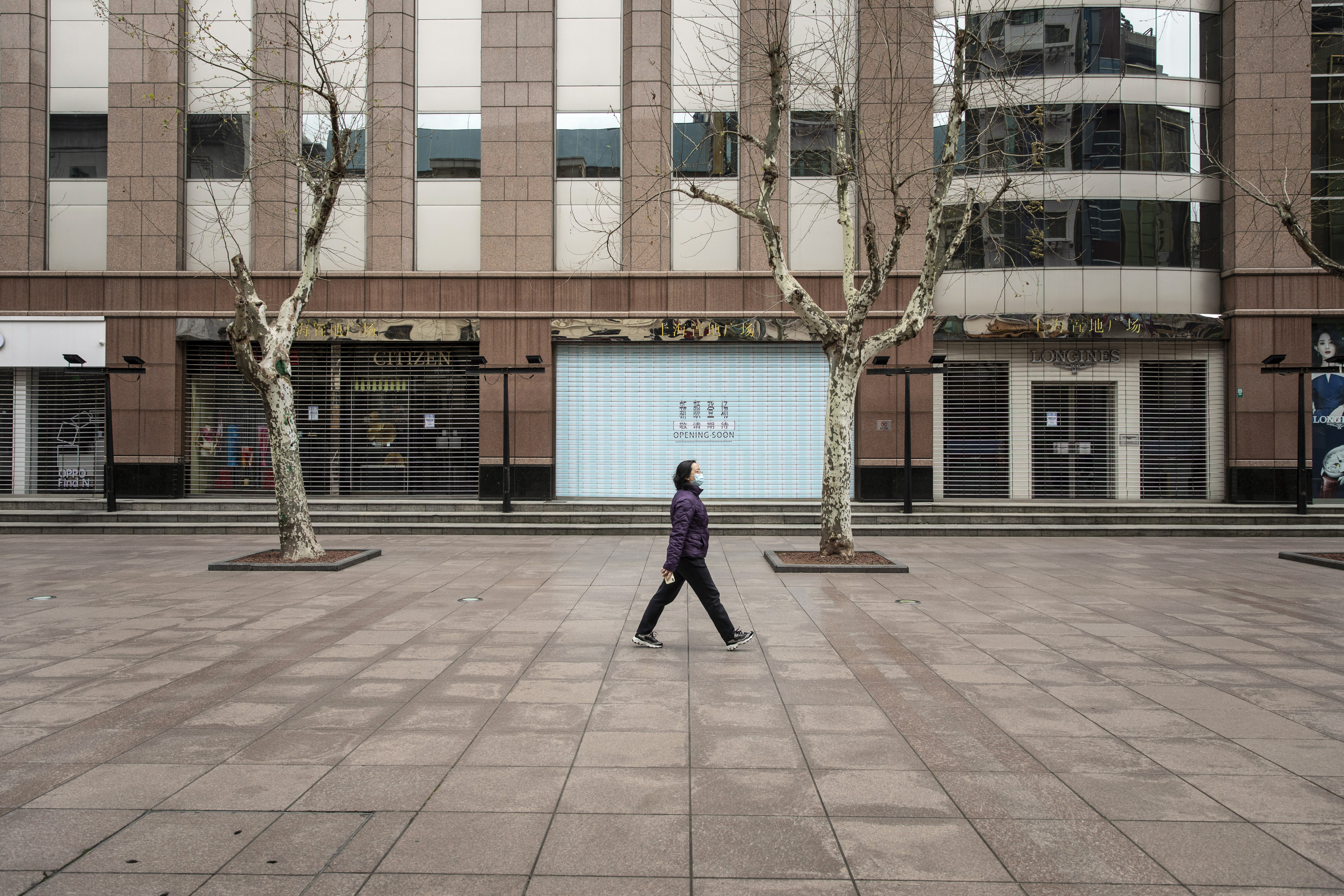 A lone pedestrian passes shuttered stores along the near-empty Nanjing Road shopping street in Shanghai, where parts of the city are under lockdown. Photo: Bloomberg