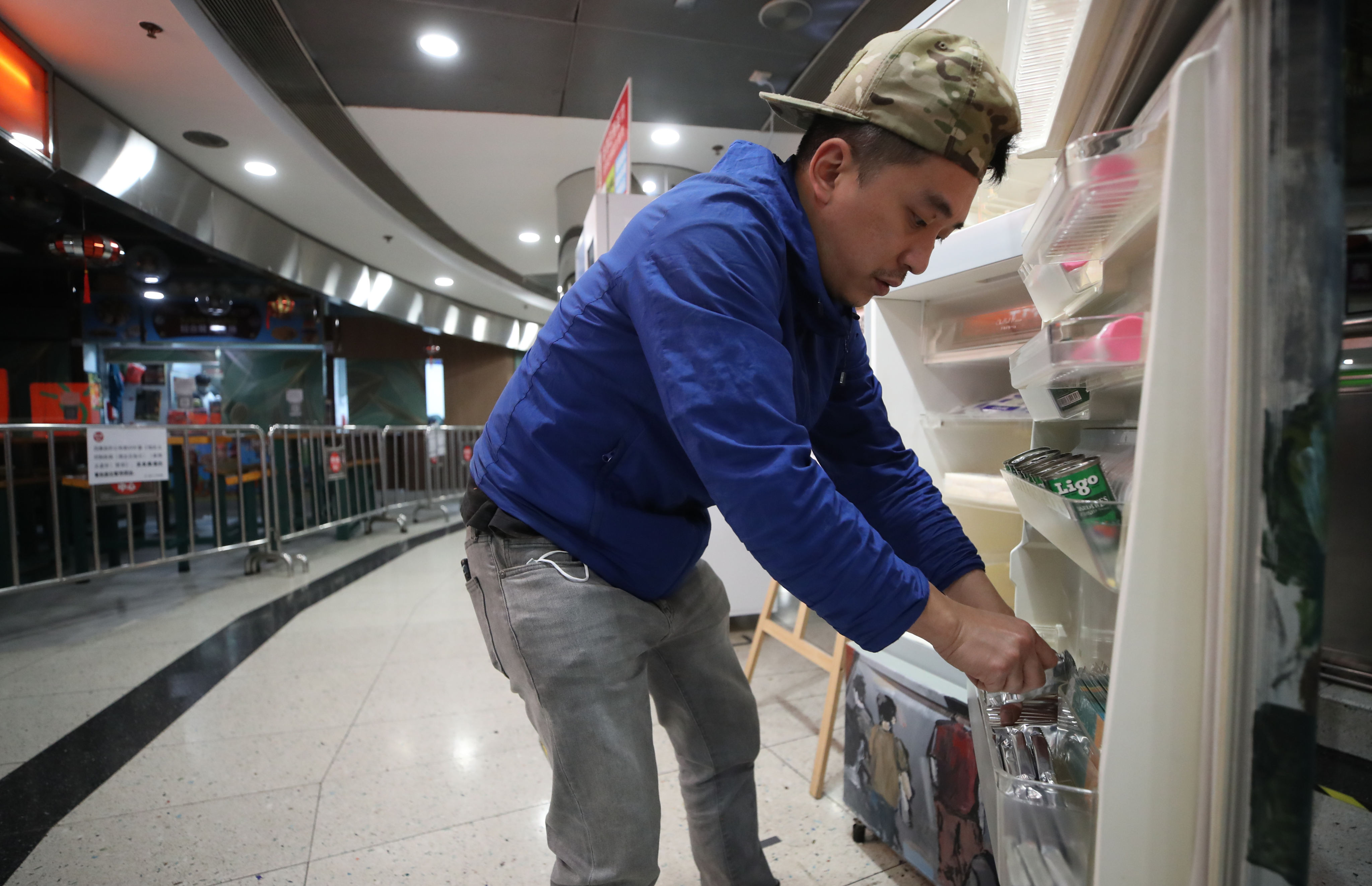 Wong Wai-kit, founder of the “Gift n Take” fridge project, replenishes food at the Dragon Centre in Sham Shui Po on March 24. He has filled about 40 fridges across Hong Kong to feed the underprivileged so they don’t have to scavenge for leftovers. Photo: Edmond So