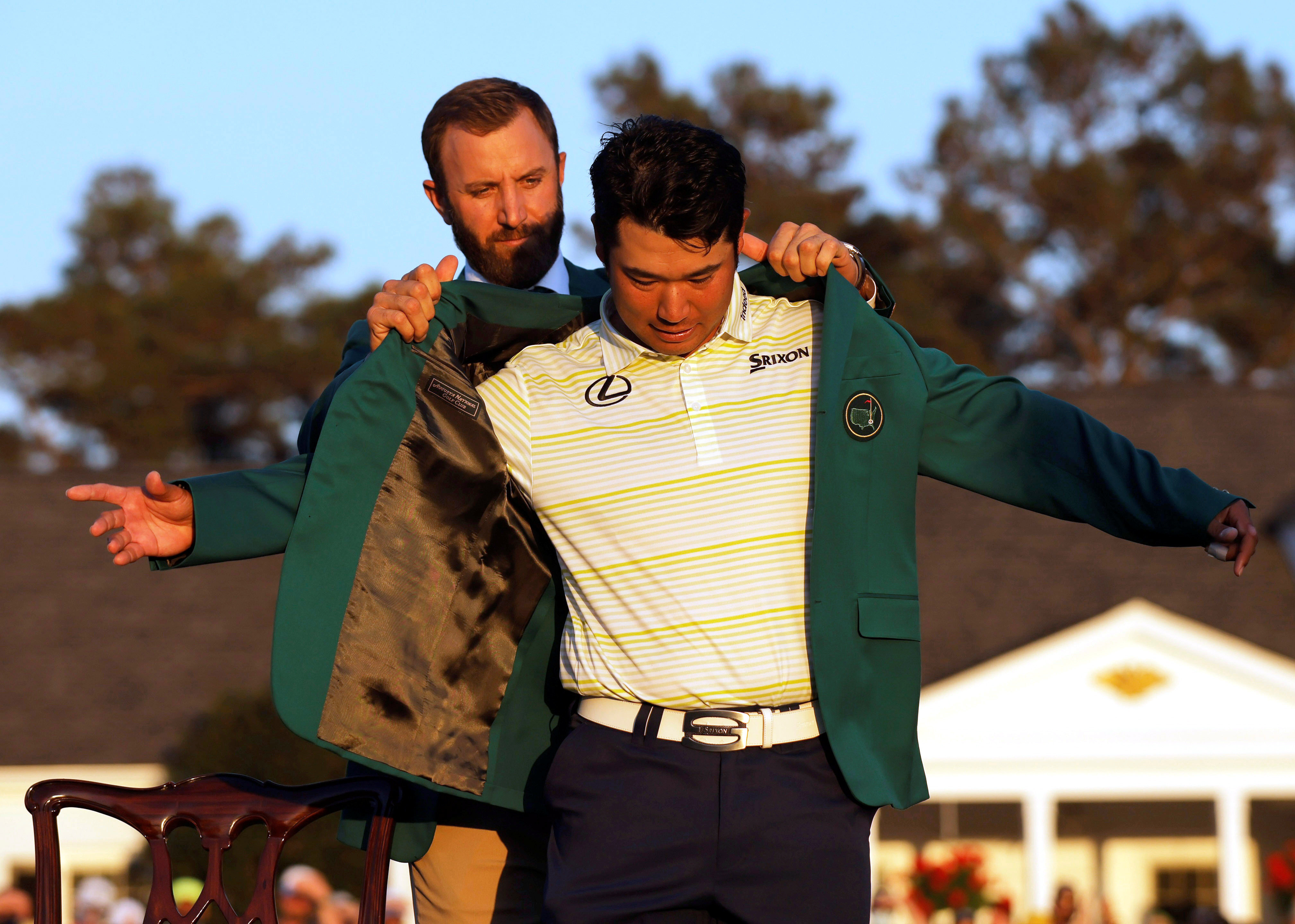 Hideki Matsuyama is presented with the green jacket by Dustin Johnson after winning The Masters in 2021. Photo: Reuters