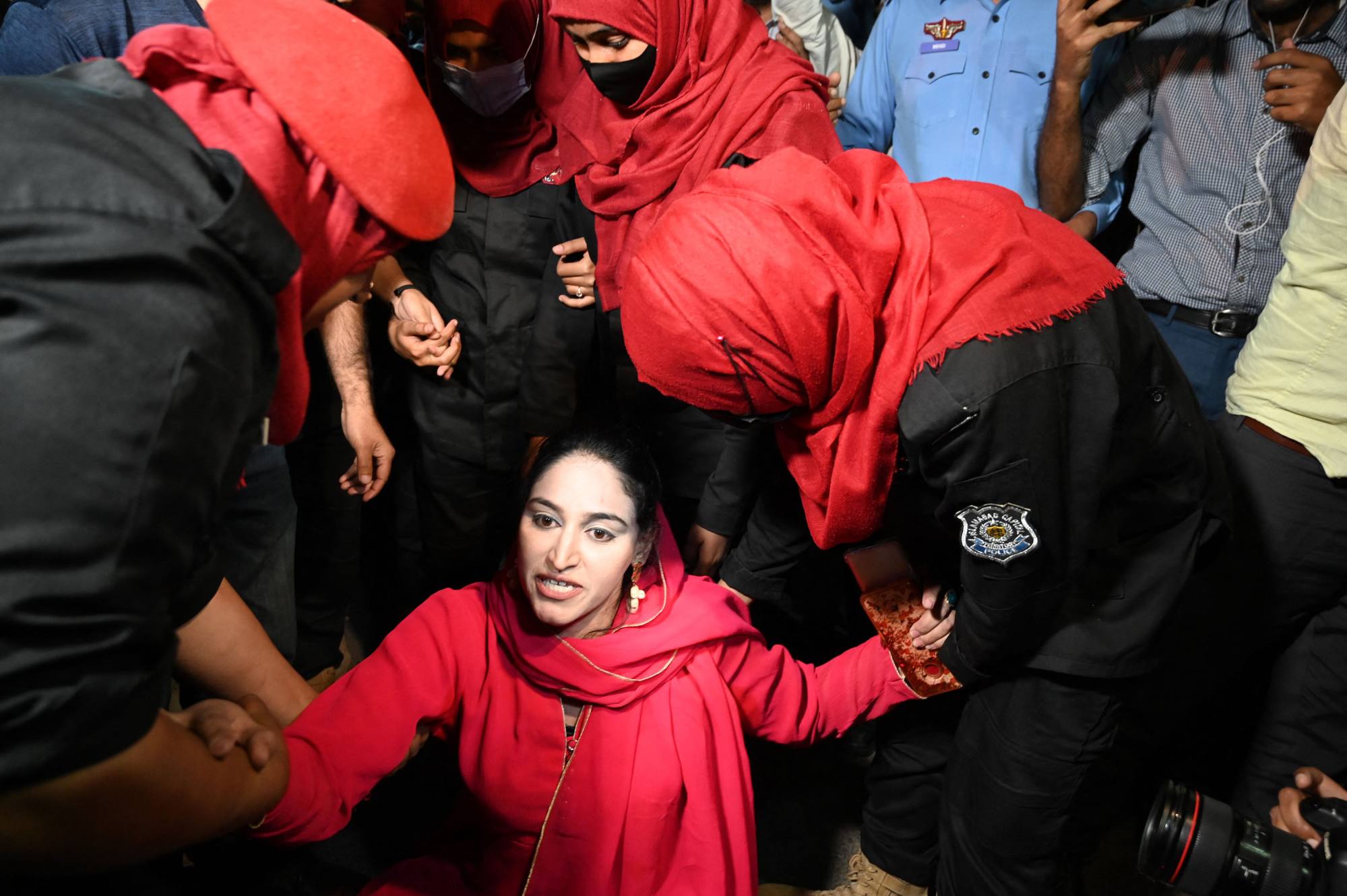 Female police officers detain a supporter of Pakistan Tehreek-e-Insaf (PTI) party outside the parliament house building in Islamabad, Pakistan on April 9. Photo: AFP