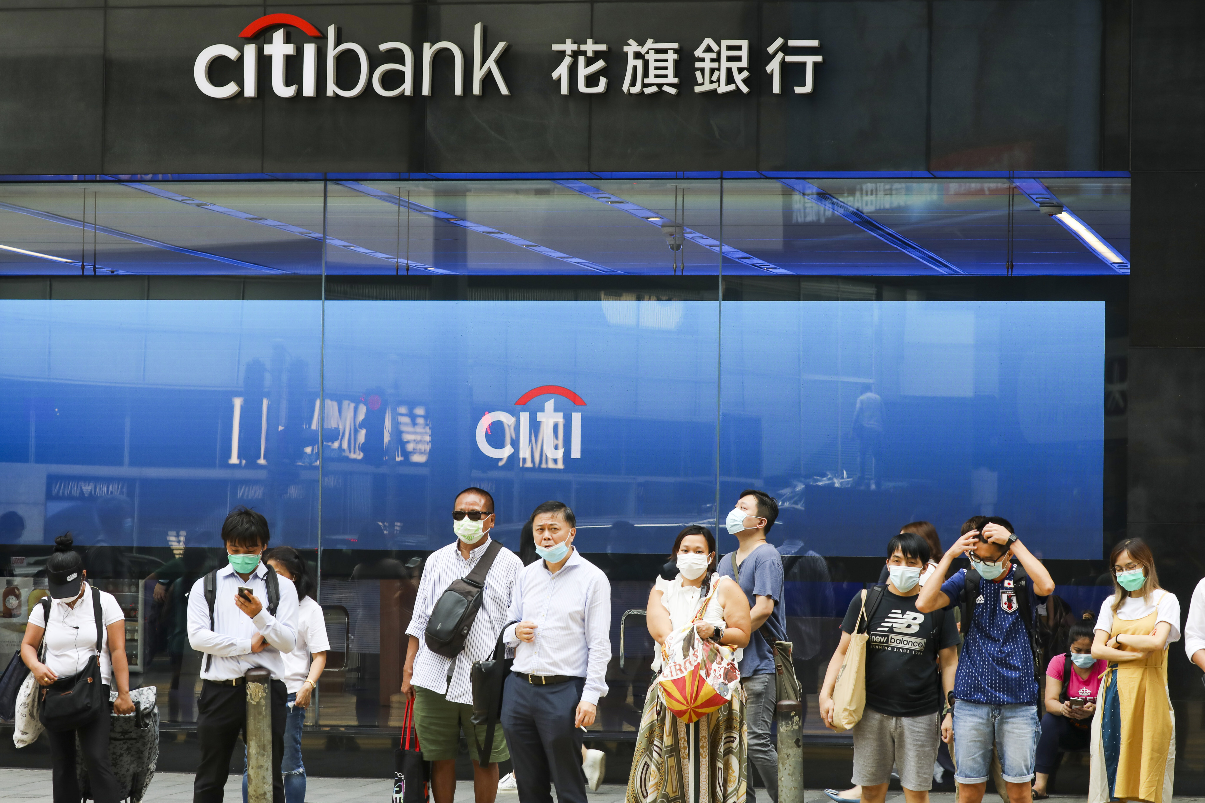 People wears a protective mask walks past the Citibank building in Central, Hong Kong in July 2020. Photo: Nora Tam