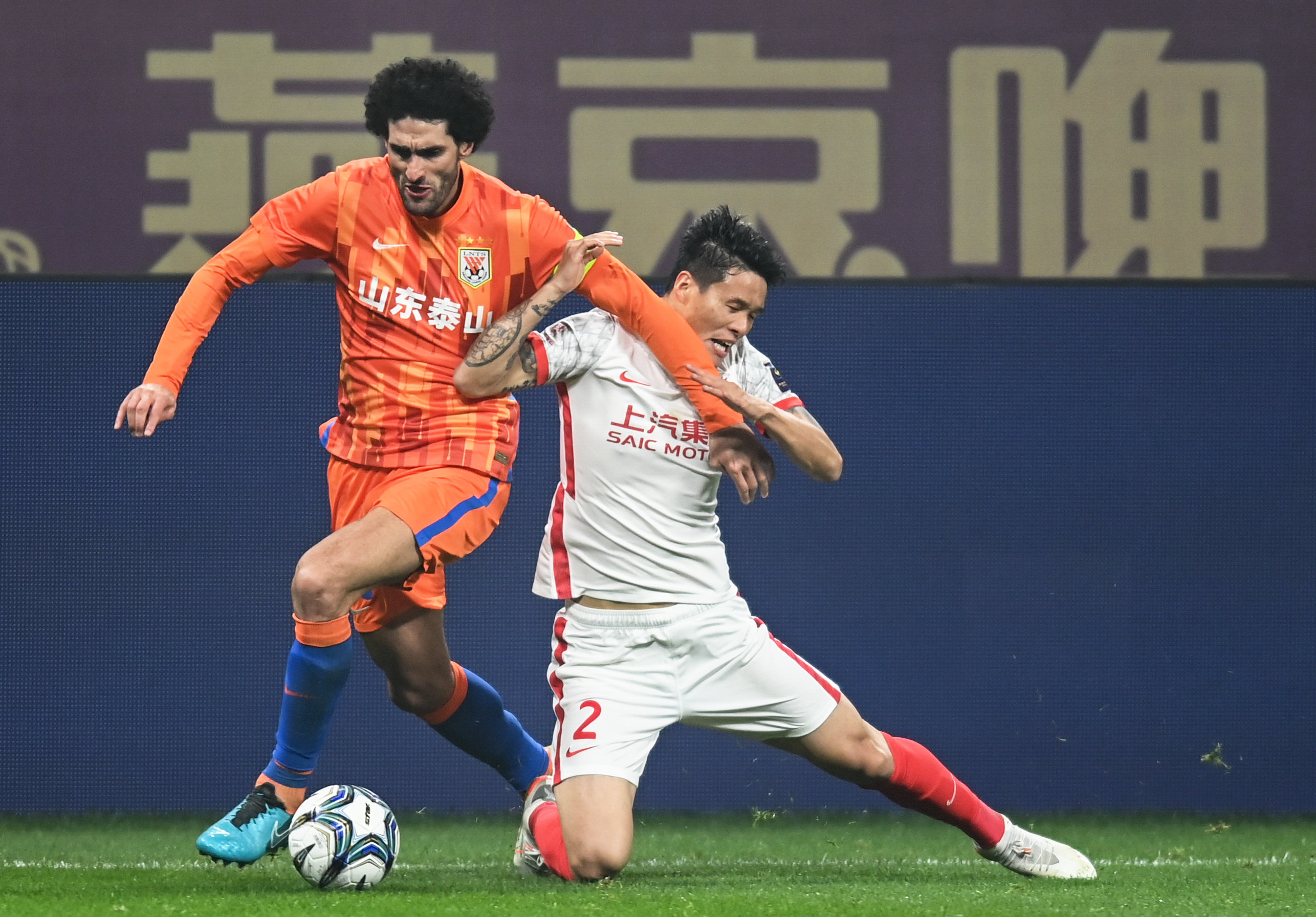 Shanghai Port’s Li Ang (right) tackles Shandong Taishan’s Marouane Fellaini during the 2021 FA Cup final in Chengdu. Photo: Xinhua