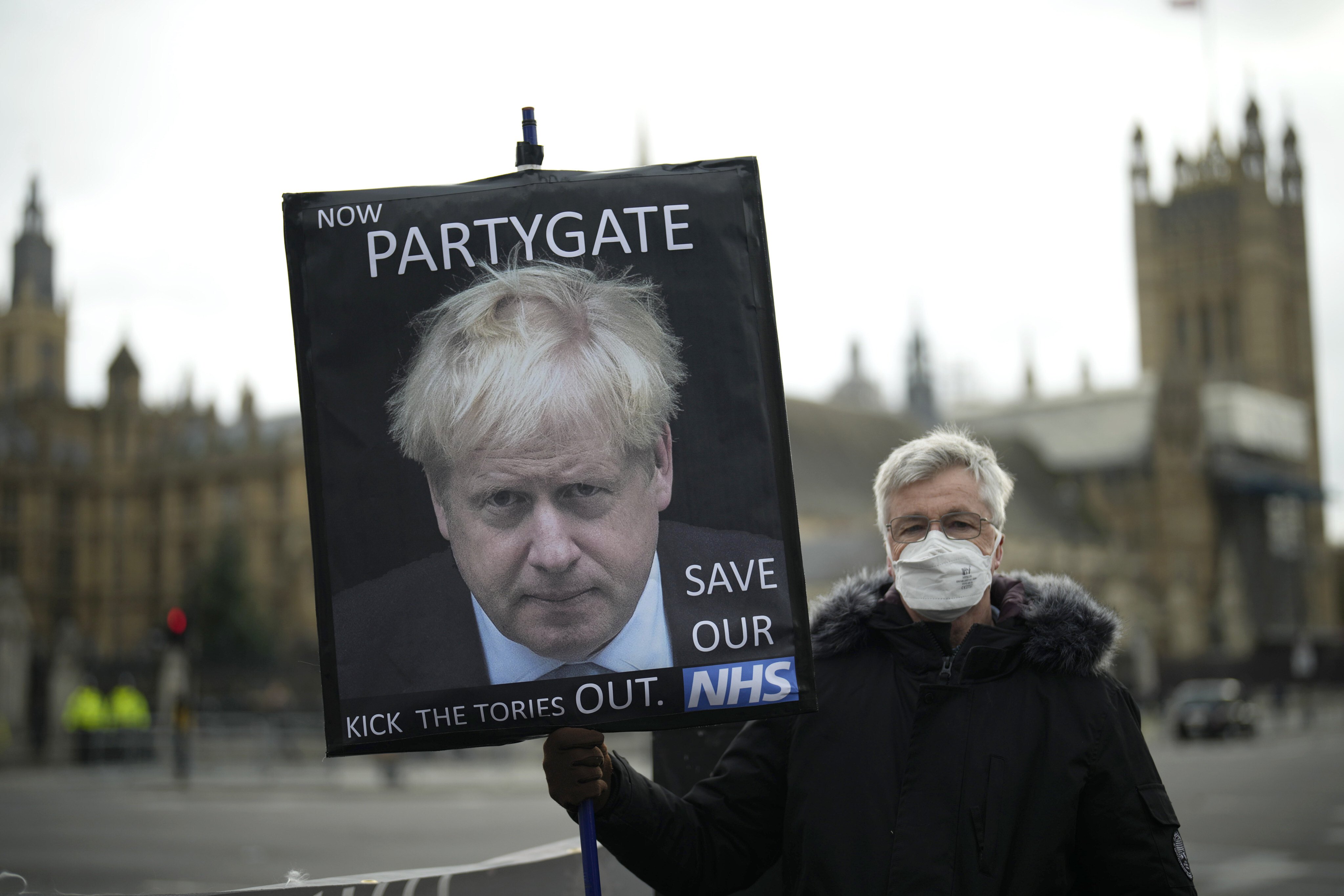 A protester in London holds a placard with an image of British Prime Minister Boris Johnson on December 8 last year. Johnson has been fined for violating coronavirus lockdown rules in 2020 by attending a number of gatherings, including his own birthday party. Photo: AP
