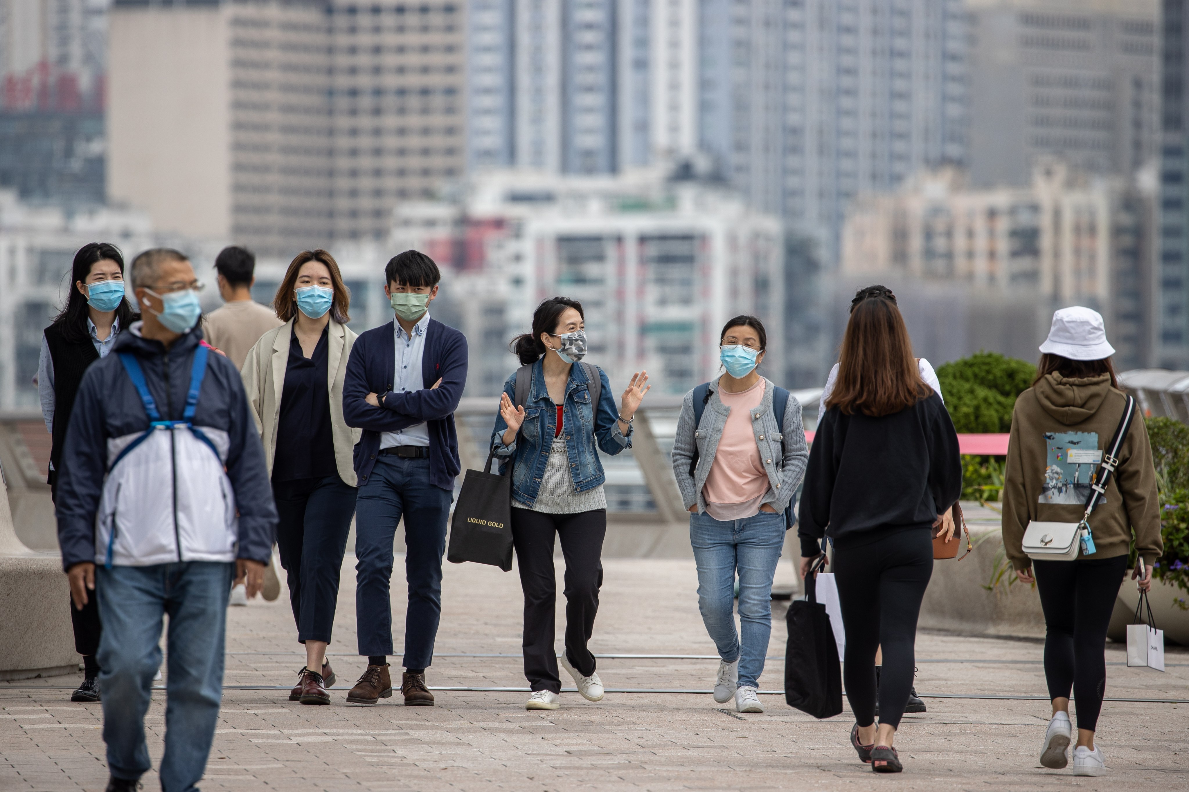 People in masks at a waterfront in Hong Kong. The city has seen Covid caseloads steadily dip. Photo: EPA-EFE