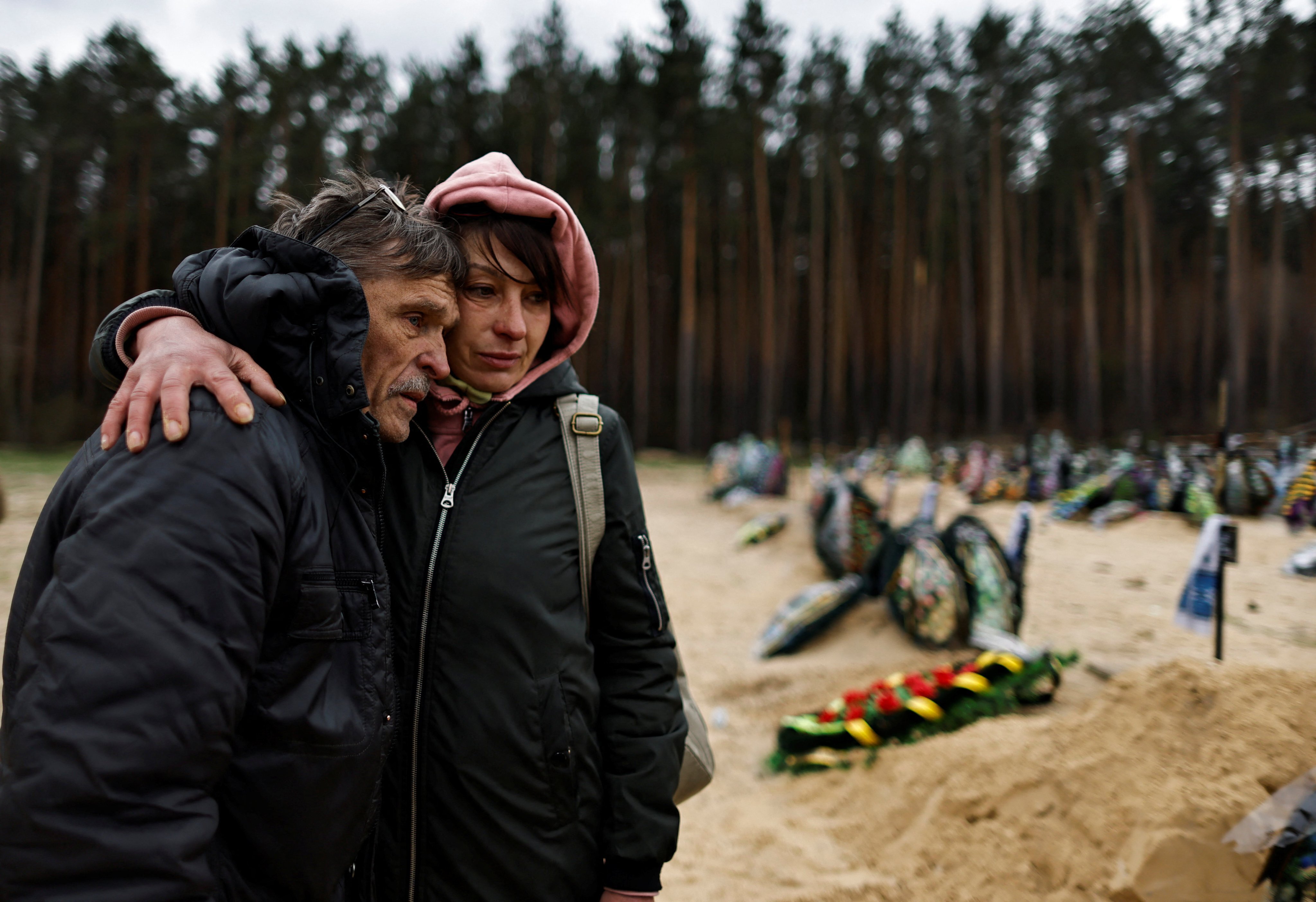Two Ukrainians mourn a relative who according to his family was killed by Russian soldiers. Photo: Reuters