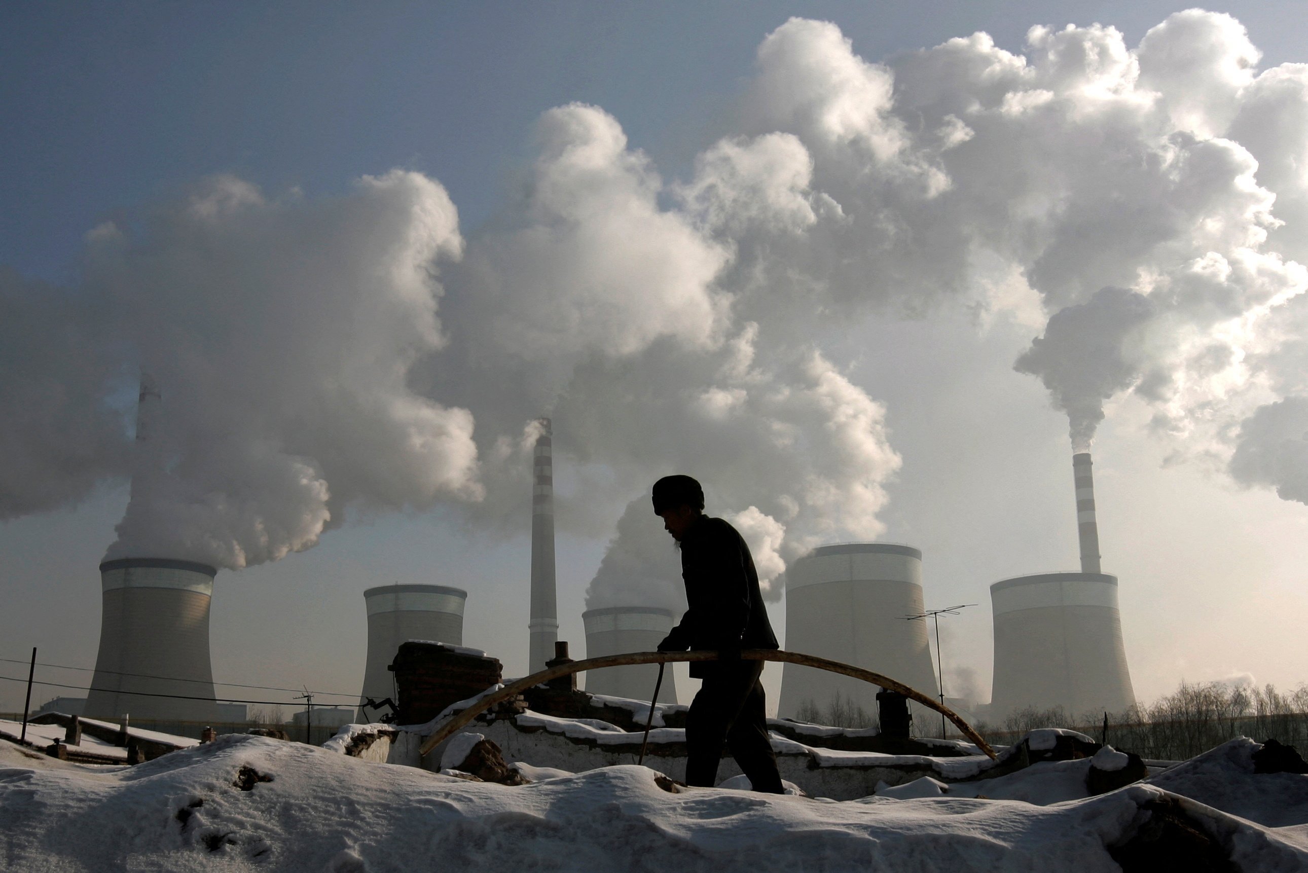 A villager walks in front of a coal-fired power plant on the outskirts of Datong, Shanxi province in China. Photo: Reuters