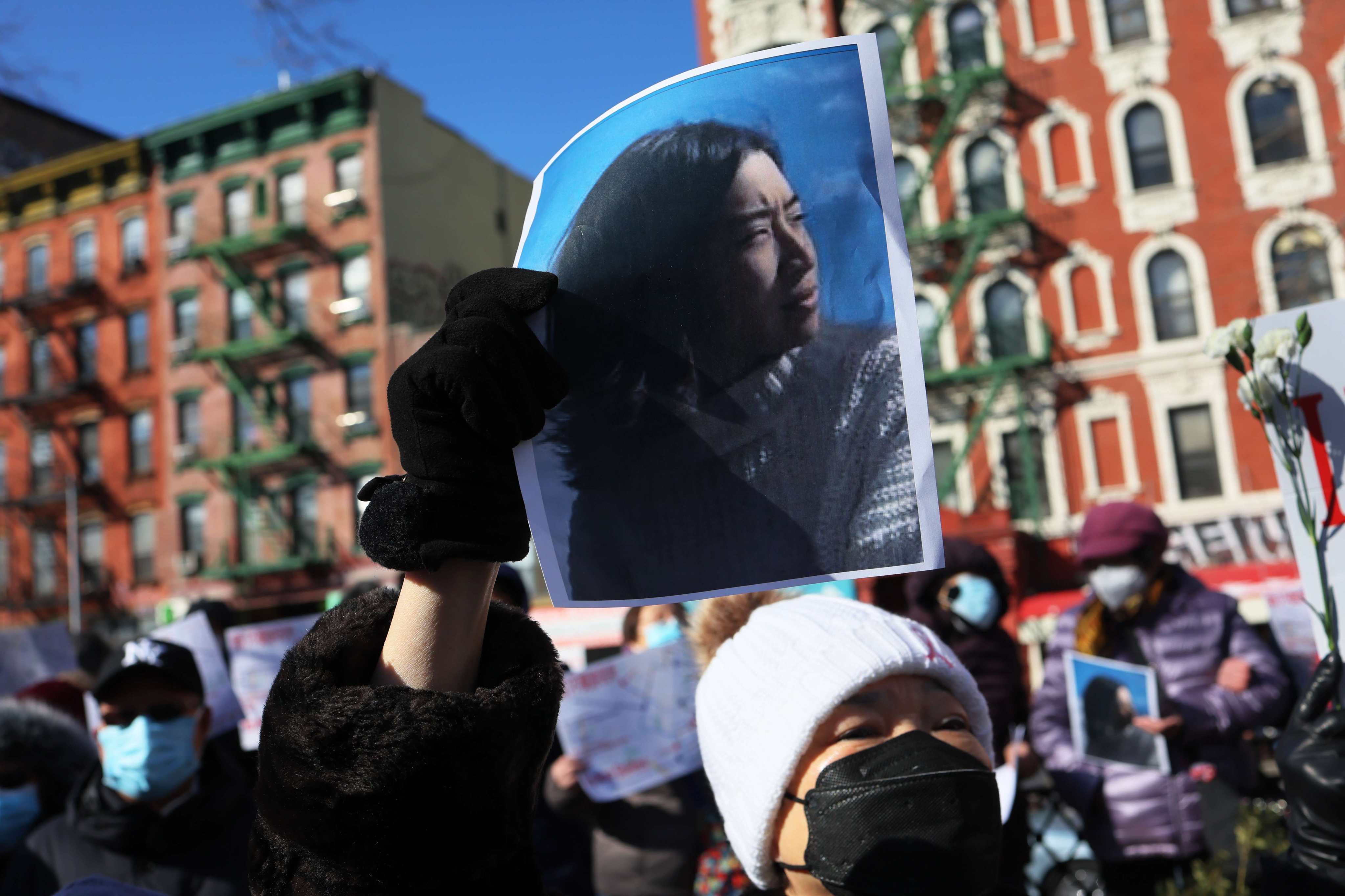 NEW YORK, NEW YORK - FEBRUARY 14: A person holds a photo of Christina Yuna Lee as people gather for a rally protesting violence against Asian-Americans at Sara D. Roosevelt Park on February 14, 2022 in the Chinatown neighborhood in New York City. Community members and leaders gathered to protest violence against the Asian-American community in the wake of the murder of 35-year old Christina Yuna Lee. Lee was stabbed to death in her apartment early Sunday morning by a man who followed her into her building. Attacks on Asian-Americans have been on the rise amid the coronavirus (COVID-19) pandemic.   Michael M. Santiago/Getty Images/AFP
== FOR NEWSPAPERS, INTERNET, TELCOS & TELEVISION USE ONLY ==