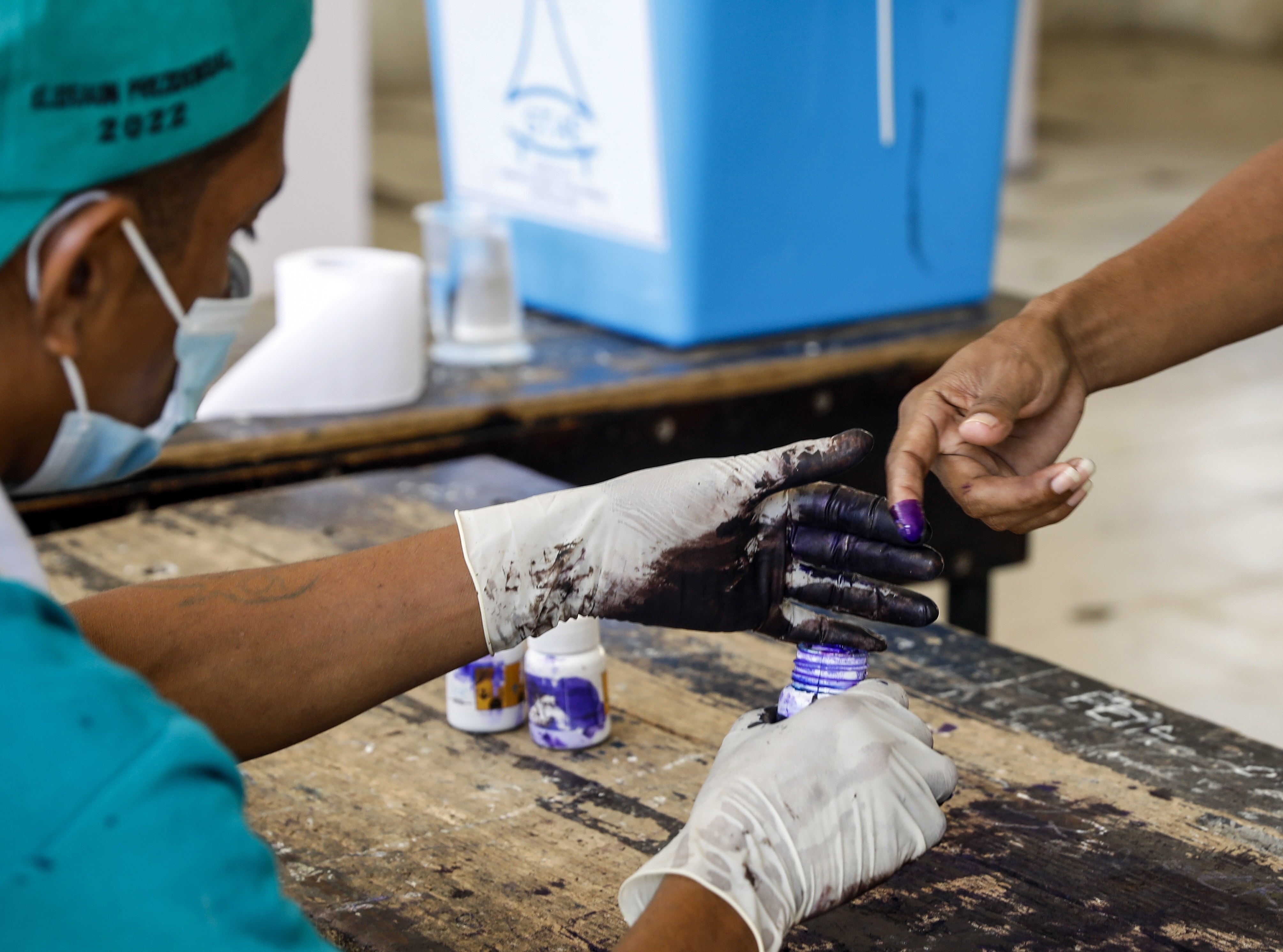 An election worker marks the finger of a voter with ink during the presidential runoff election at a polling station in Dili, East Timor on Tueday. The runoff election is between former president and Nobel Peace Prize laureate Jose Ramos Horta, and incumbent president Francisco Guterres. Photo: EPA-EFE