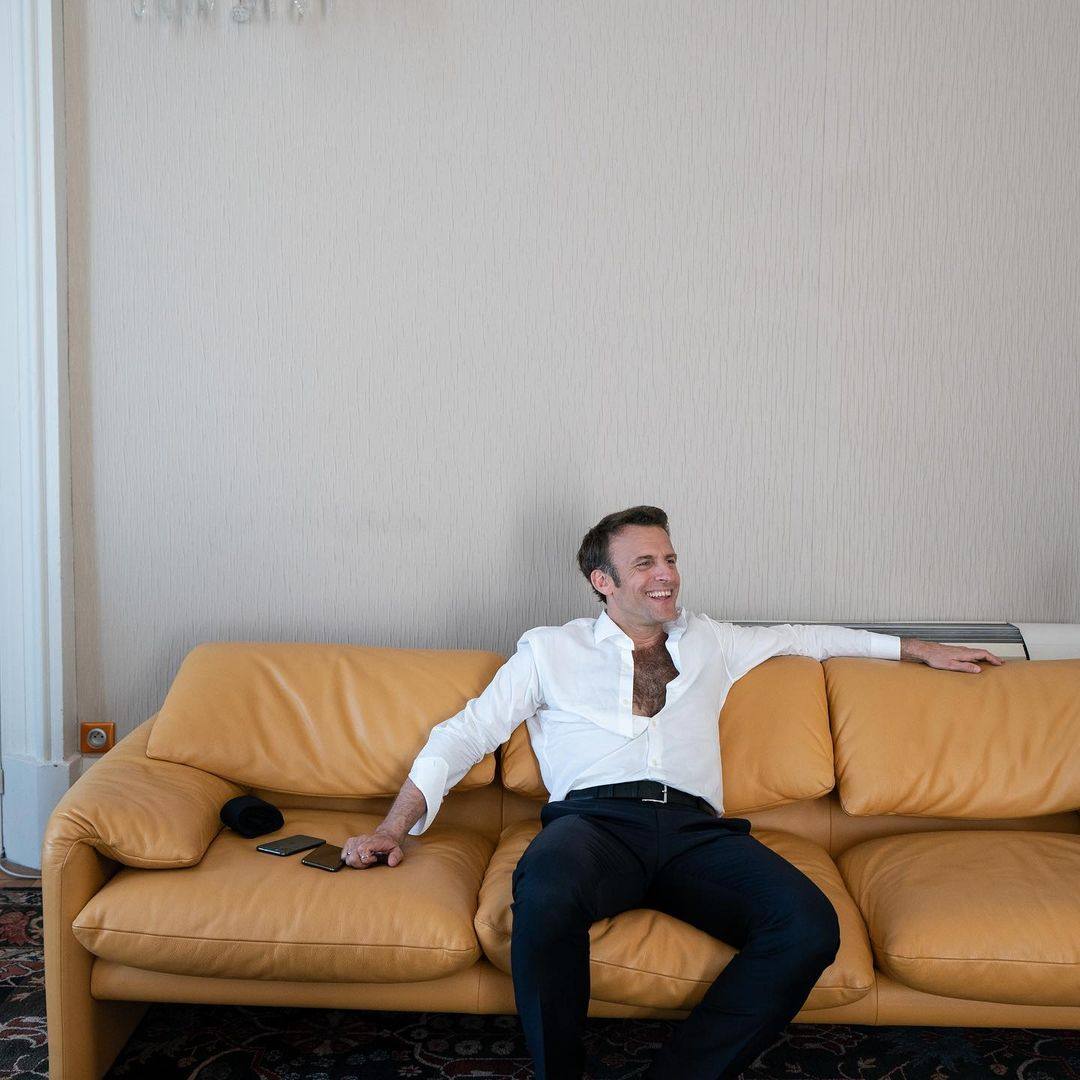 French President Emmanuel Macron reclines on a sofa, the top four buttons of his white shirt undone to reveal a full pelt of dark chest hair - an image that saw social media users compare him to Sean Connery and Tarzan. Photo: Soazig de la Moissonnière