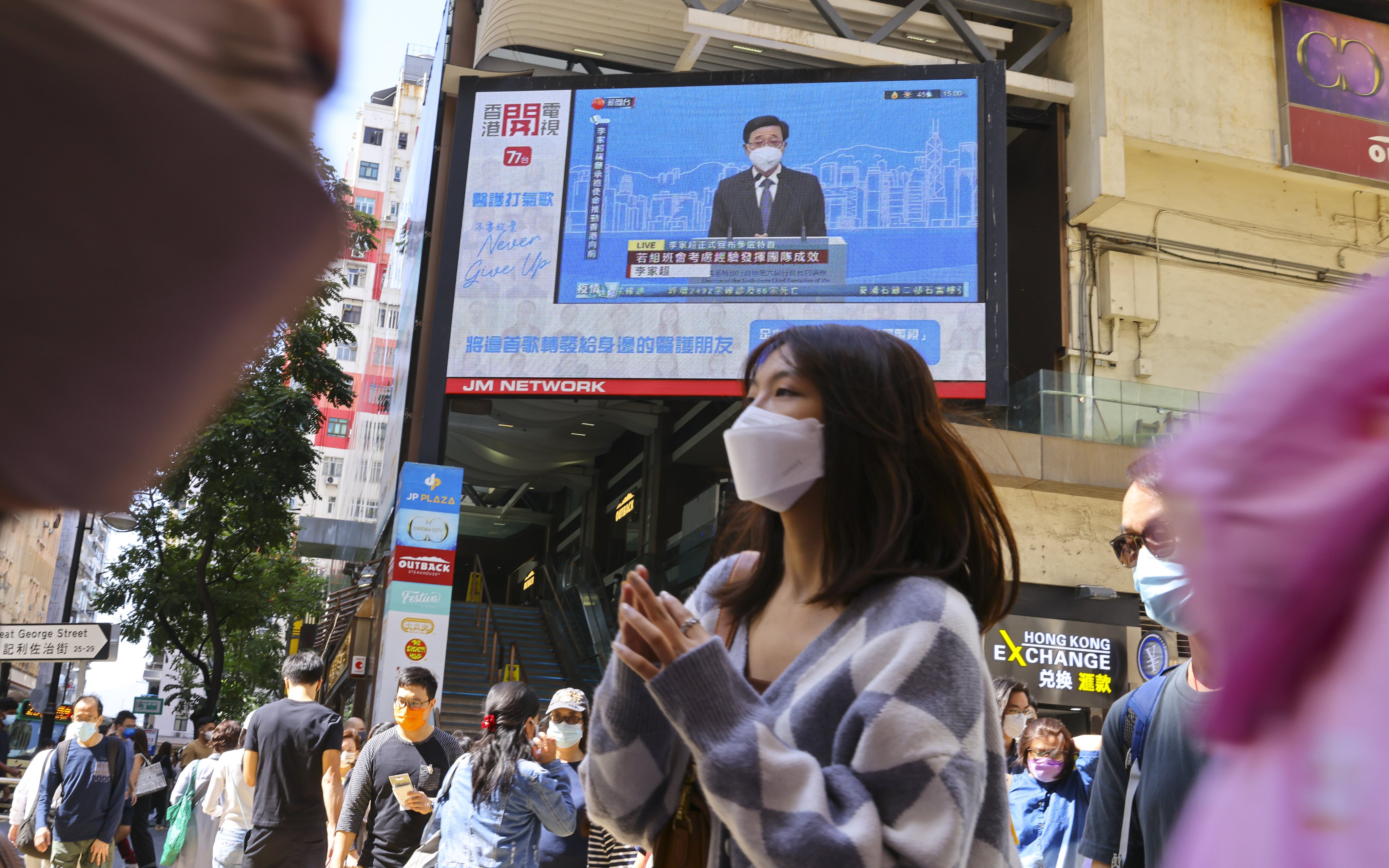 A live broadcast of an online press conference by chief executive hopeful John Lee is shown in Causeway Bay on April 9. Photo: Dickson Lee