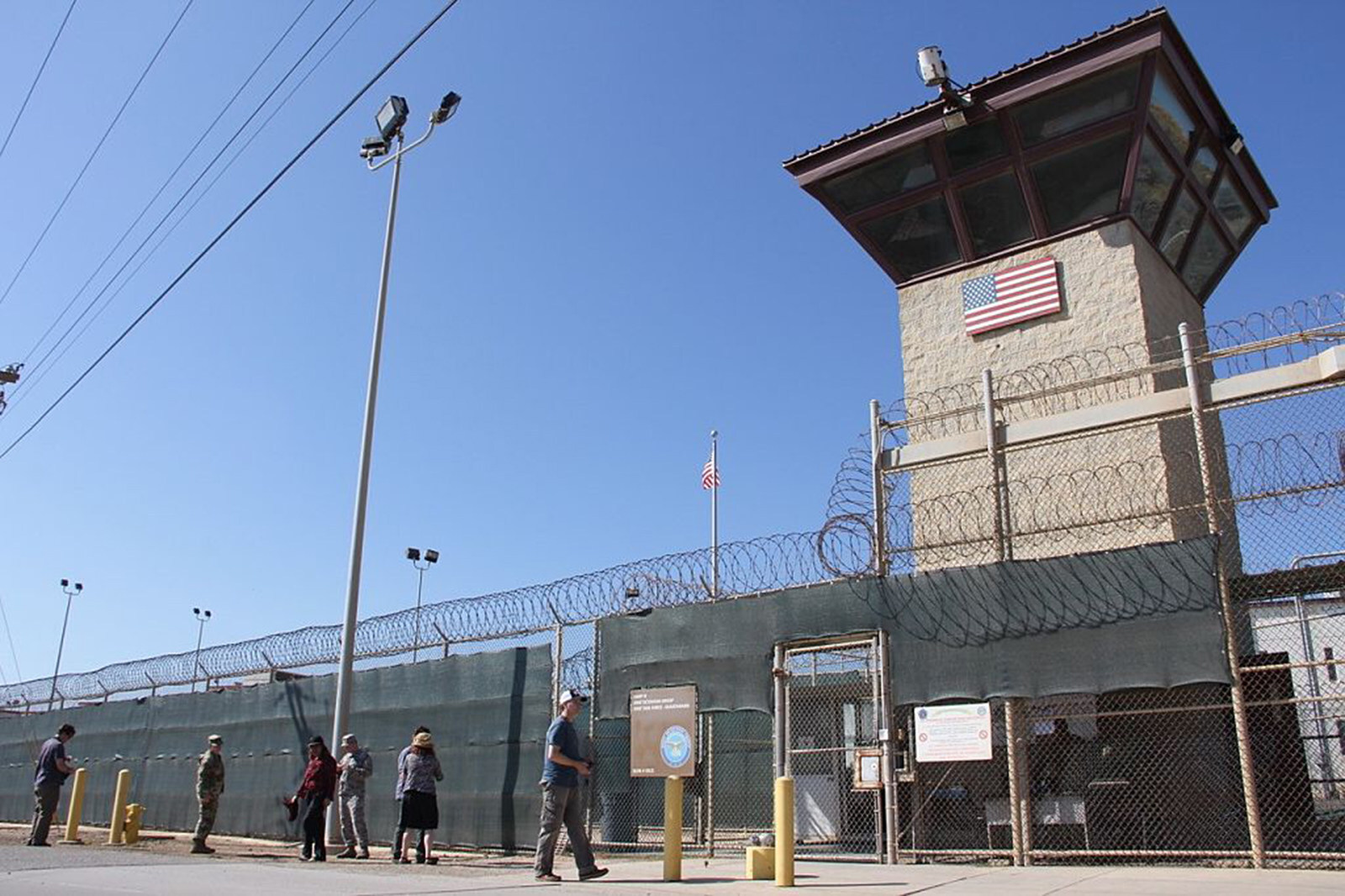 People walk past a guard tower outside the US Military’s prison in Guantanamo Bay, Cuba. Photo: AFP via Getty Images / TNS