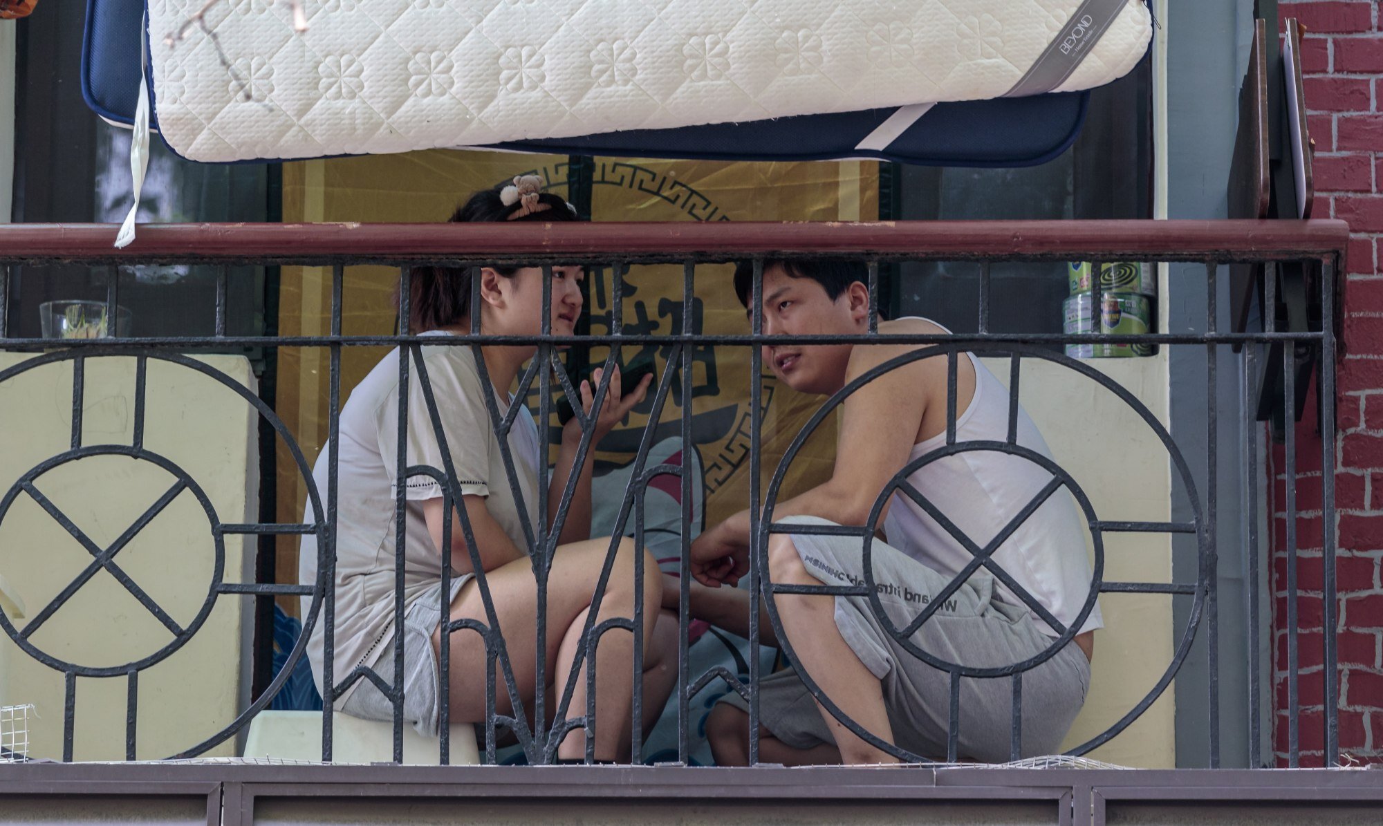 A couple under quarantine sits on their balcony during the city lockdown in Shanghai on 25 April 2022. Photo: EPA-EFE
