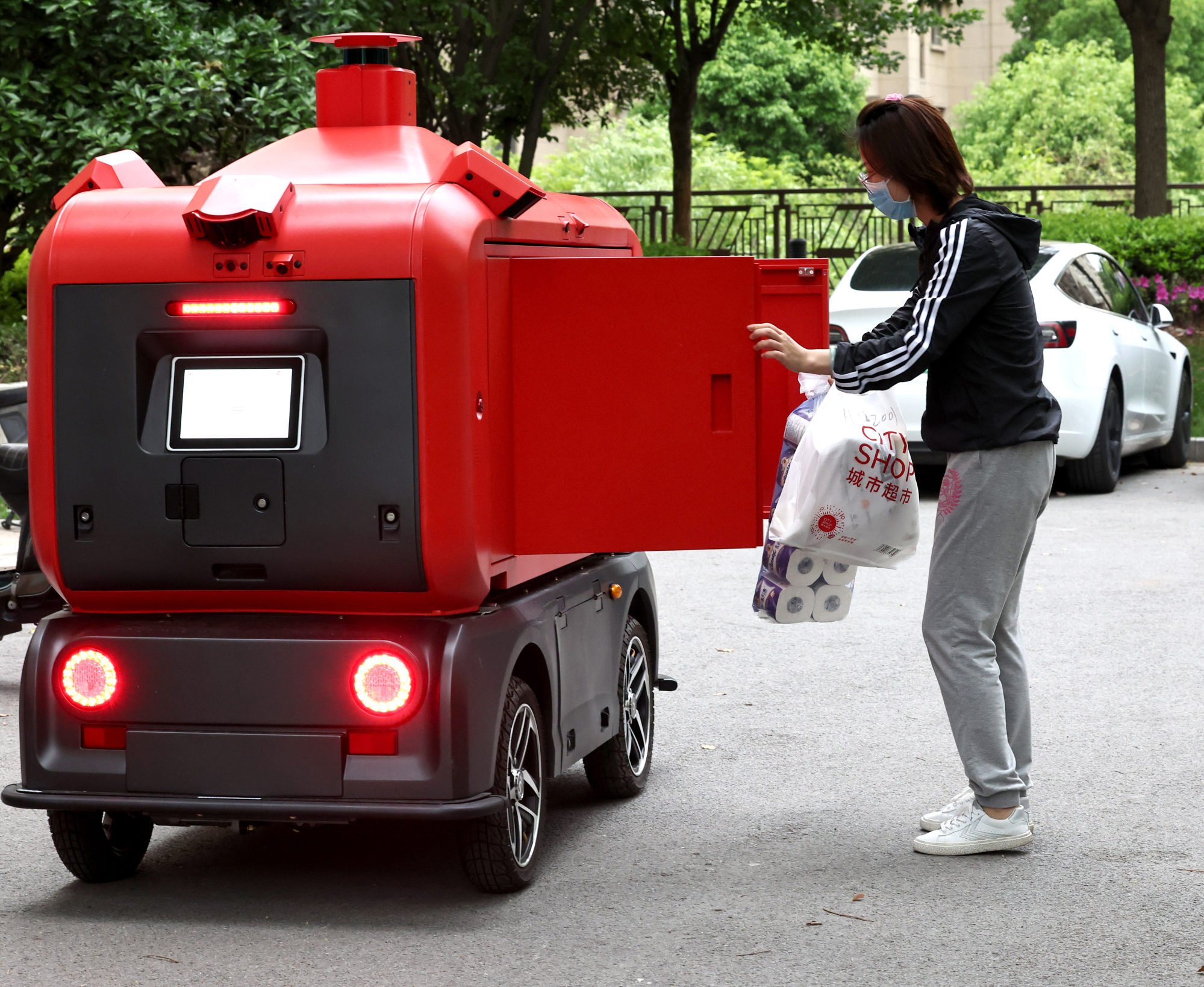 A resident collects goods from an unstaffed delivery vehicle in a community of Jiading district in Shanghai on April 25, 2022. Photo: Xinhua