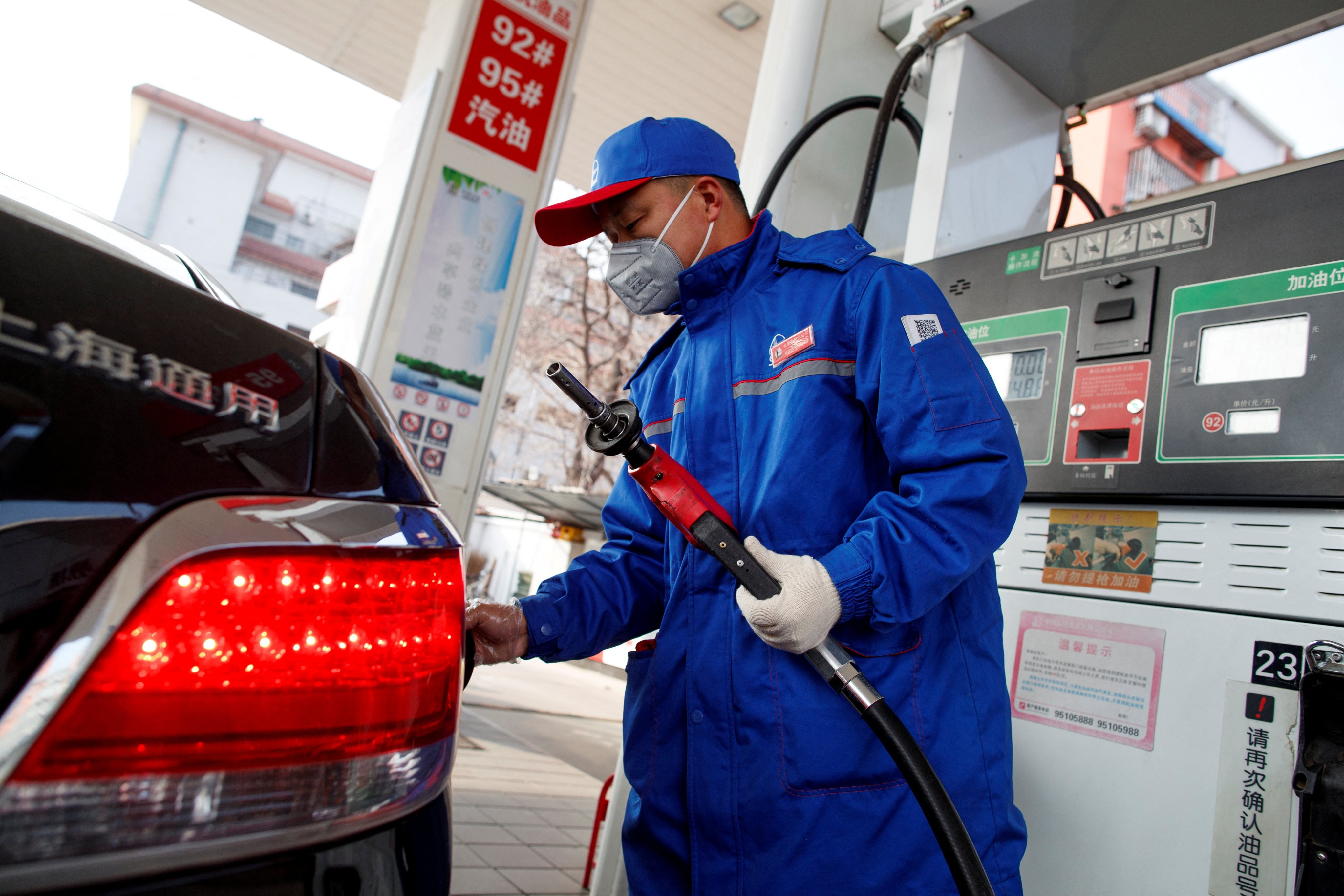 A pump attendant refuelled a car at a Sinopec gas station in Beijing on February 28, 2020. Photo: Reuters