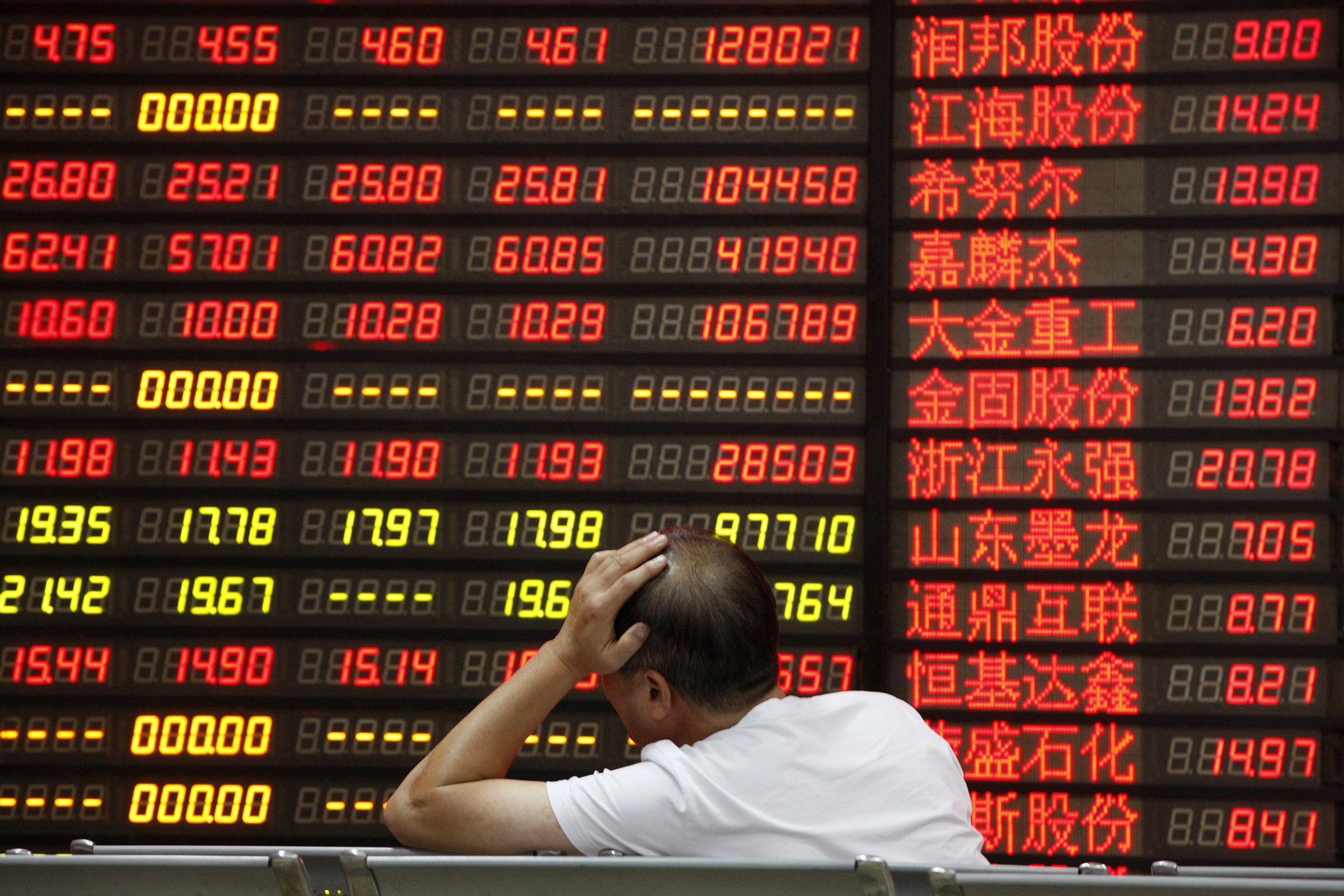 An investor watchs an electronic board showing stock prices in Huaibei, in eastern Chinese province of Anhui. Photo: Shutterstock