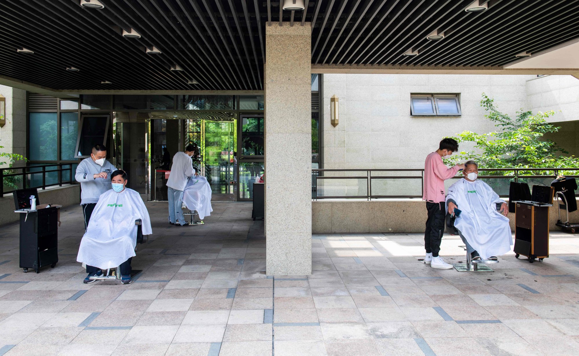 Community volunteers gave haircuts to residents in a “precautionary zone” compound – where no cases had been reported in the preceding 14 days – in Shanghai’s Pudong district on May 1, 2022. Photo: AFP