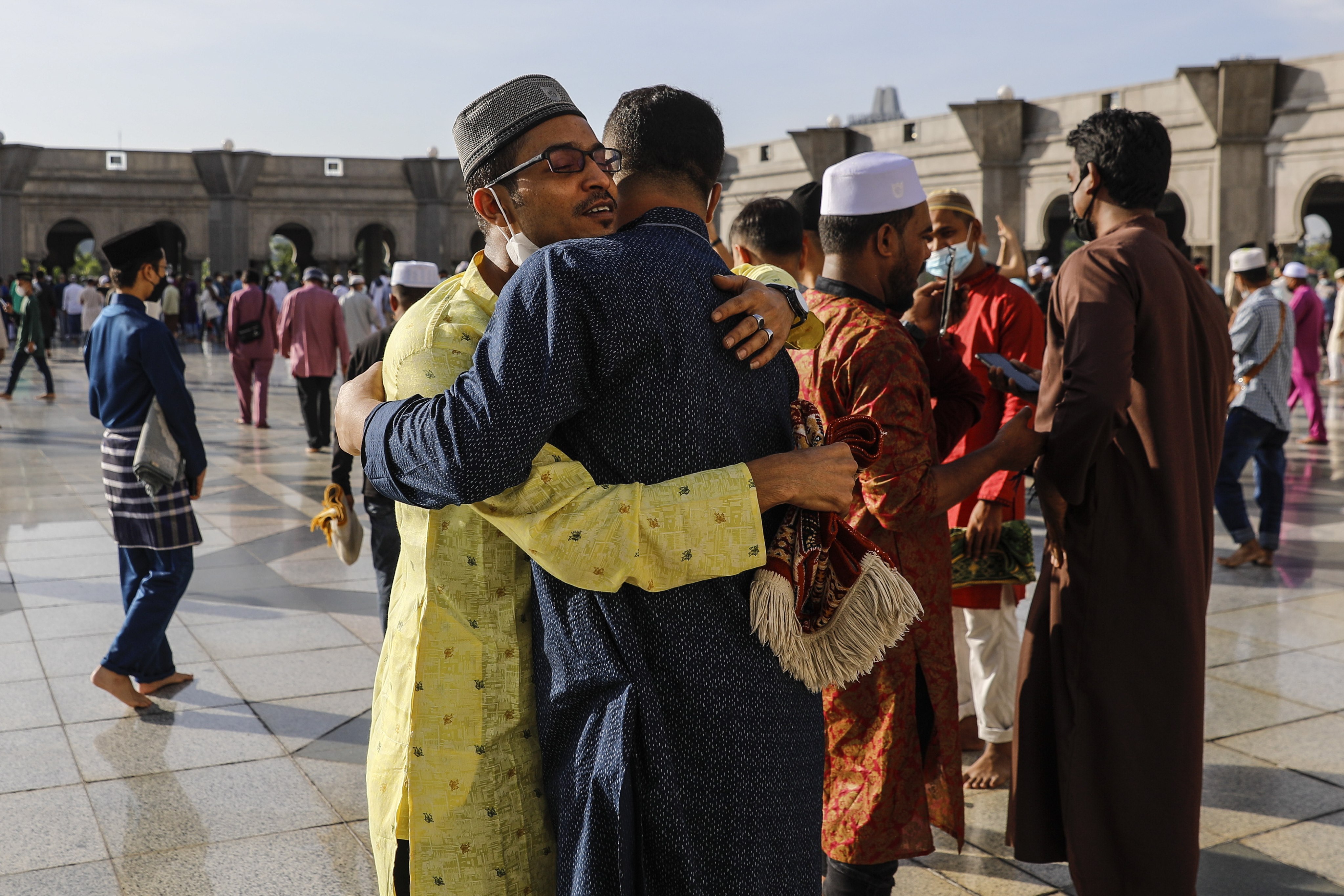 Two men embrace after taking part in Eid al-Fitr prayers in Kuala Lumpur on Monday. Photo: EPA-EFE