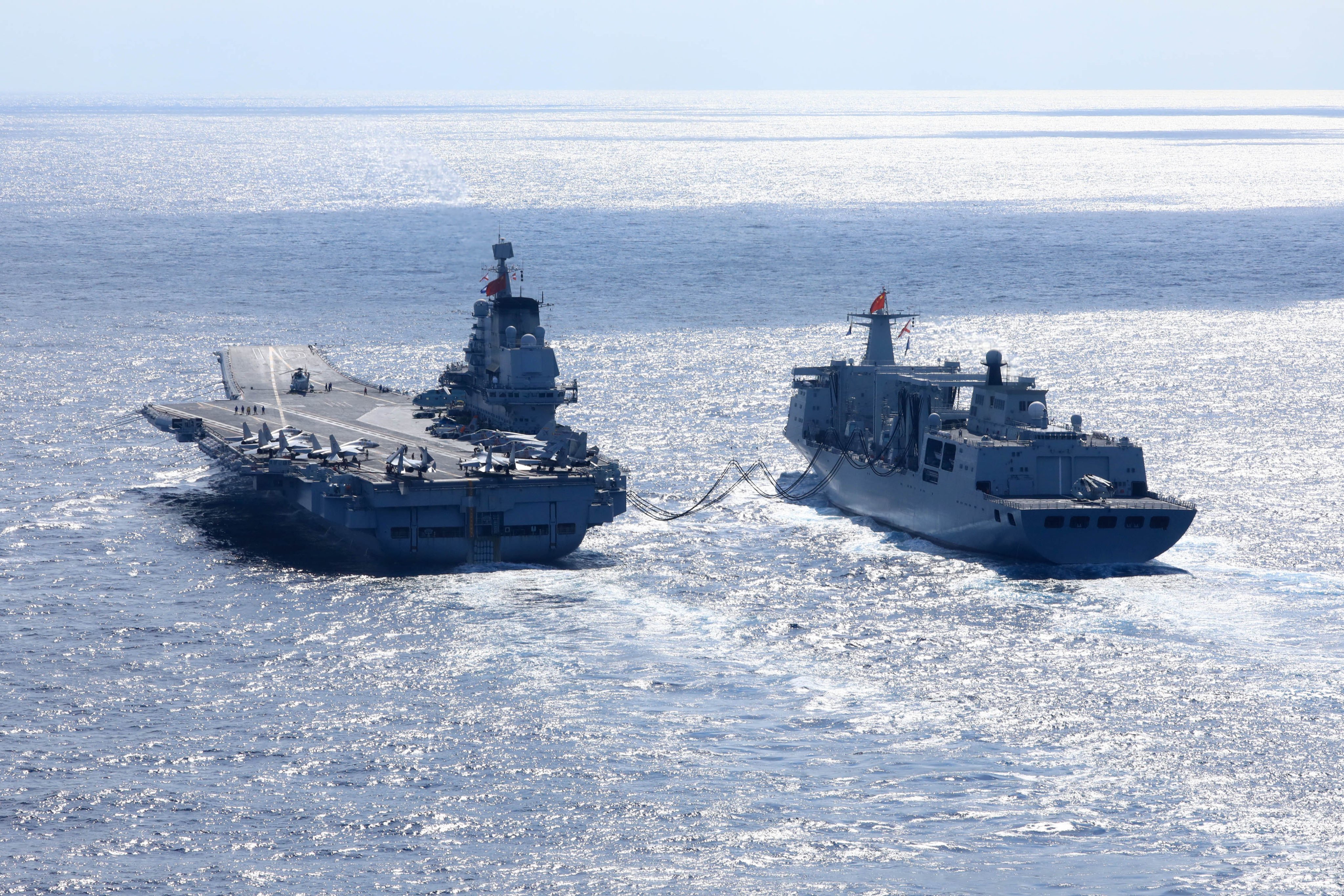 PLA Navy aircraft carrier Liaoning (left) takes part in open-seas combat training. Photo: Xinhua