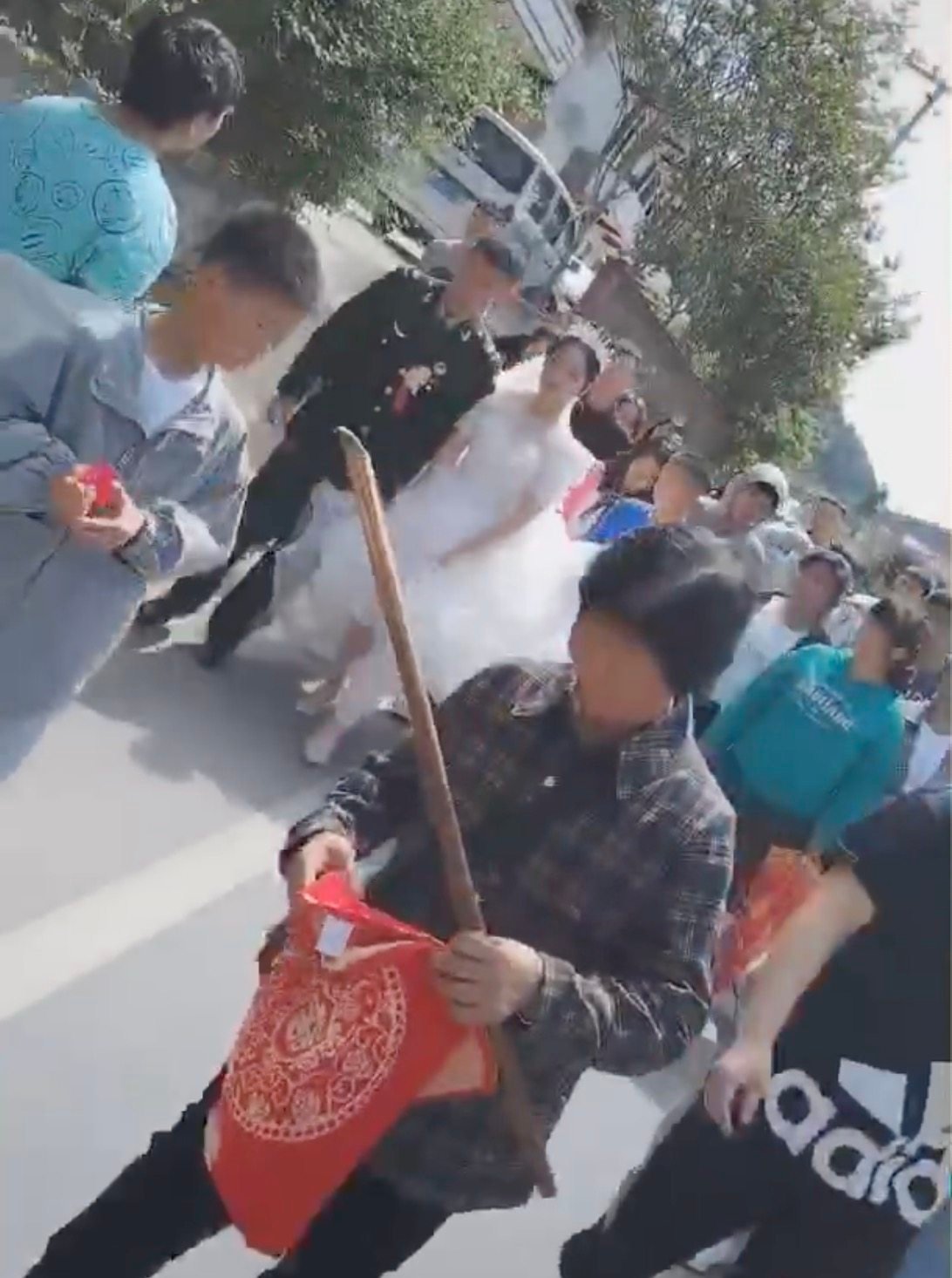 A Chinese grandma wields a stick to prevent wedding pranks. Photo: Douyin
