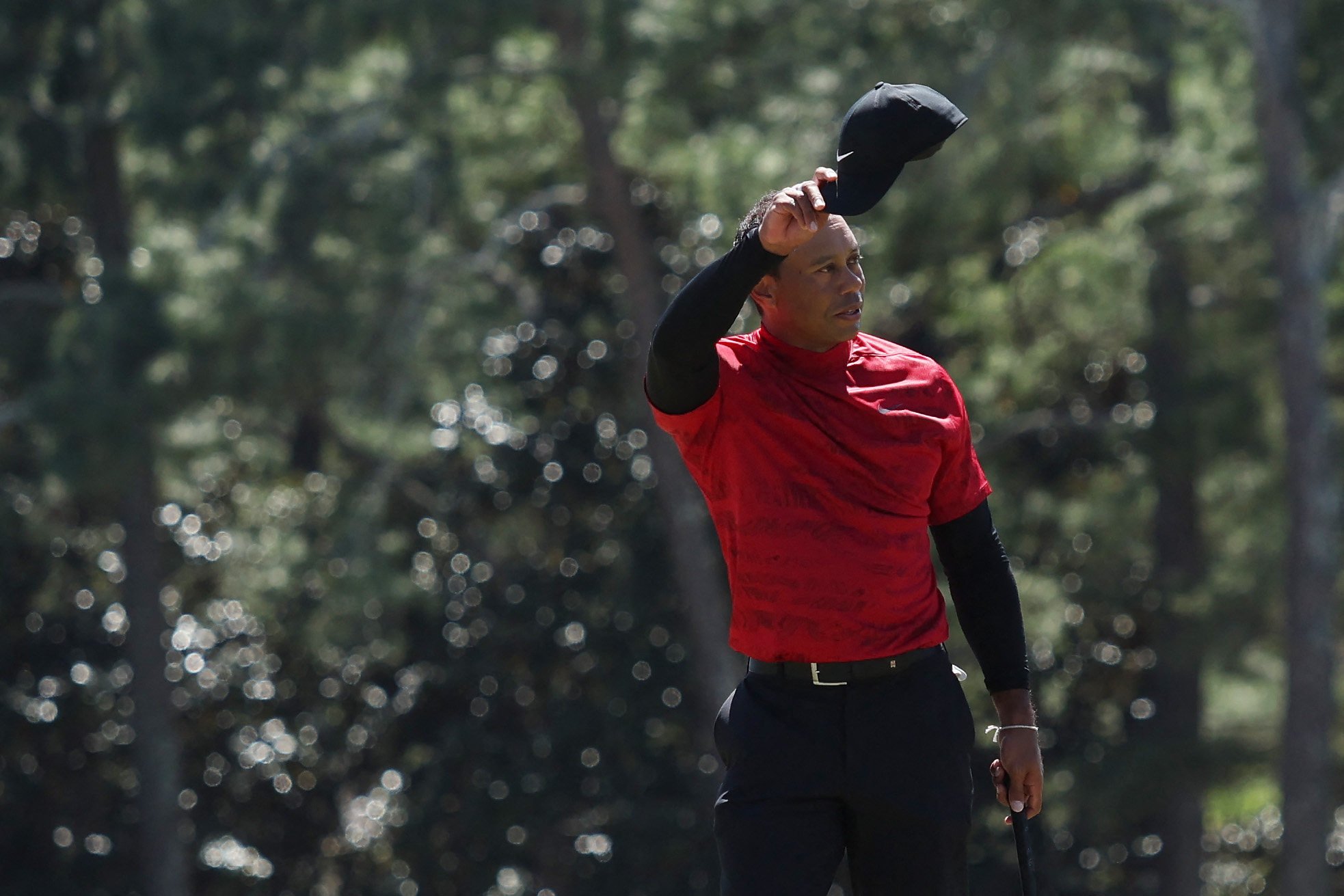 Tiger Woods tips his hat to the crowd on the 18th green after finishing his round during the Masters at Augusta National Golf Club. Photo: AFP
