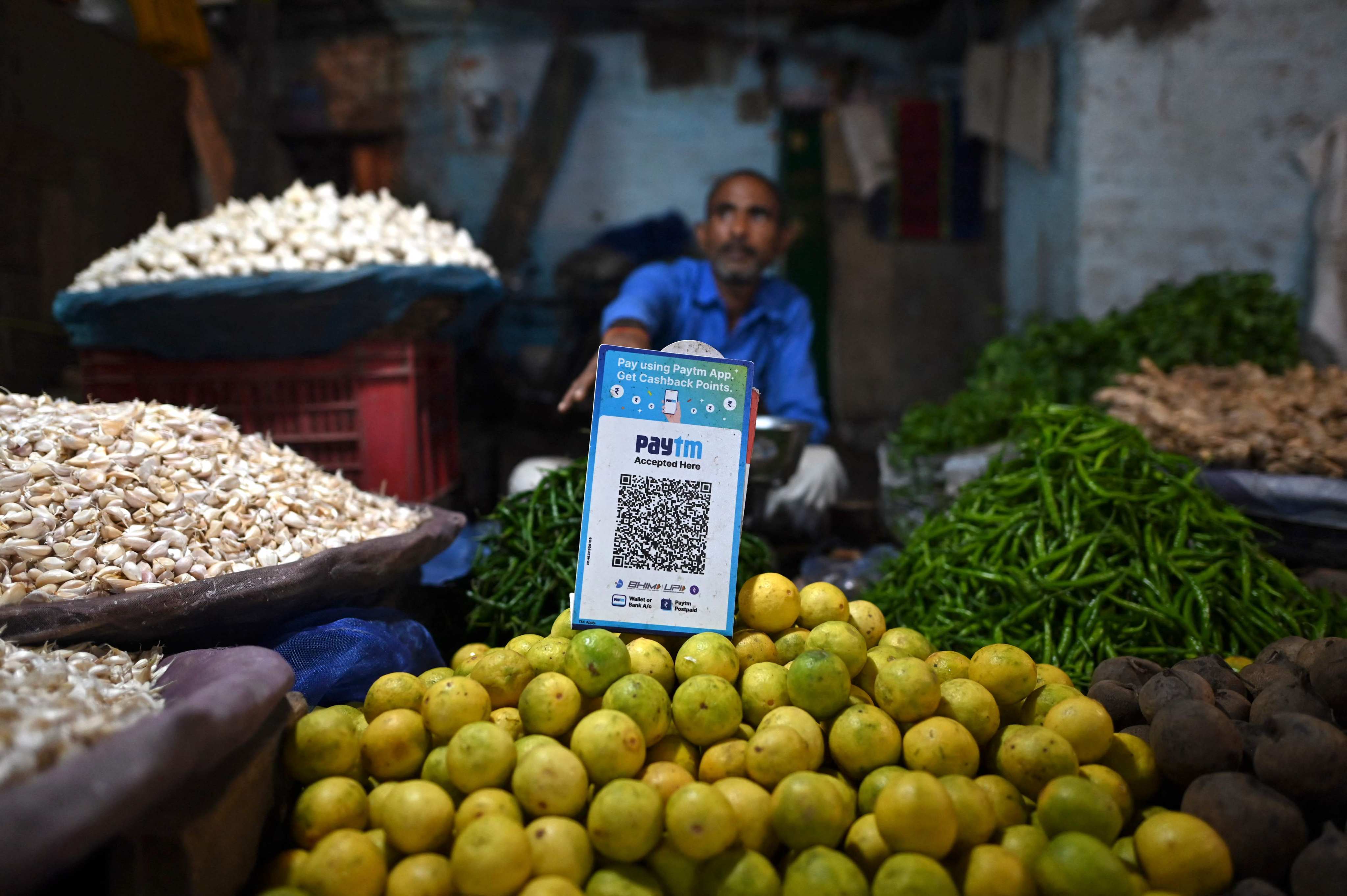 A vegetable vendor’s stall has a barcode for Paytm, an Indian cellphone-based digital payment platform, at a market in New Delhi in November 2021. While digital payment use is growing across Asia, access to other financial products is severely lagging. Photo: AFP