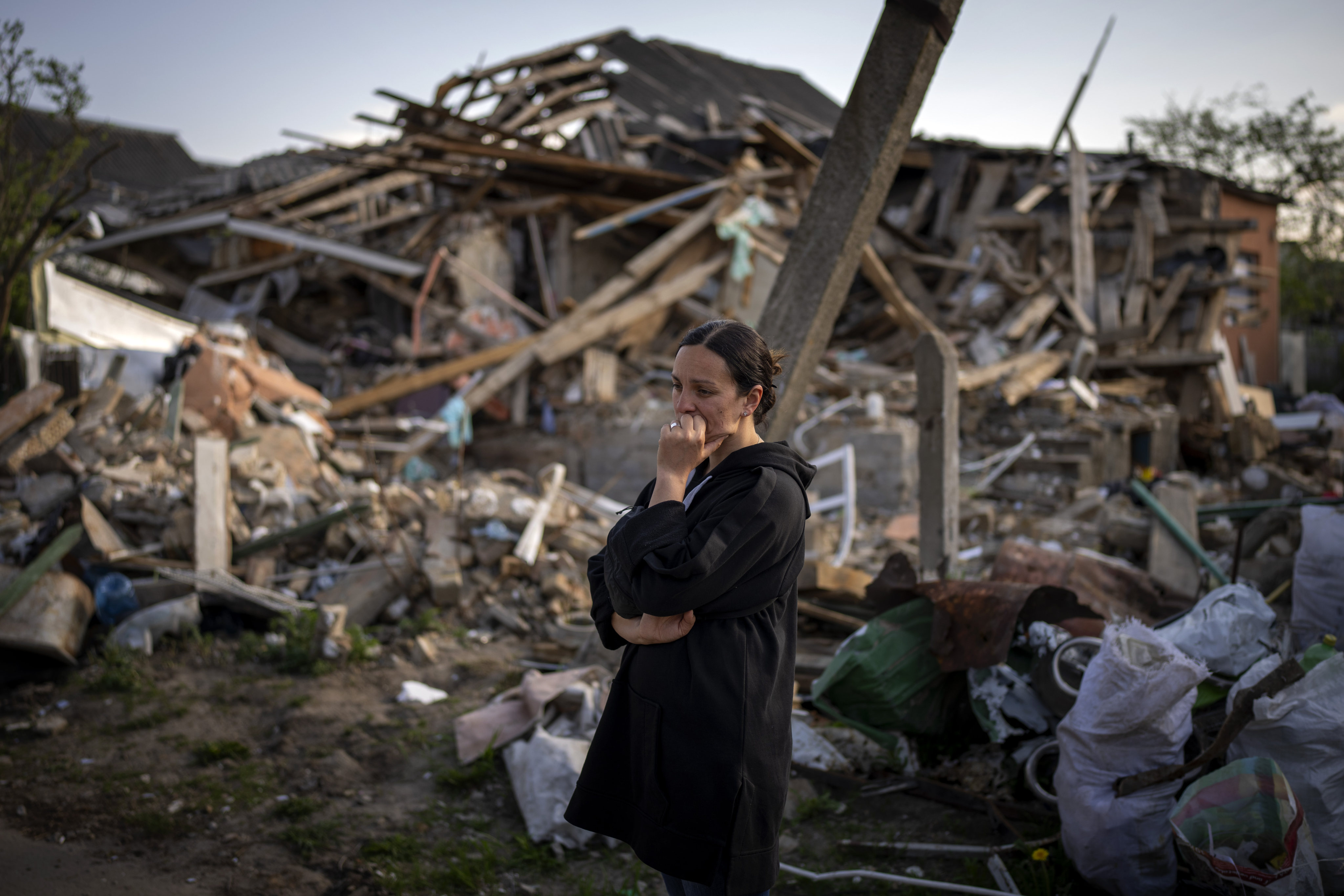 A woman stands next to her home which has been reduced to rubble in Irpin, near Kyiv in Ukraine, on May 3. Photo: AP 