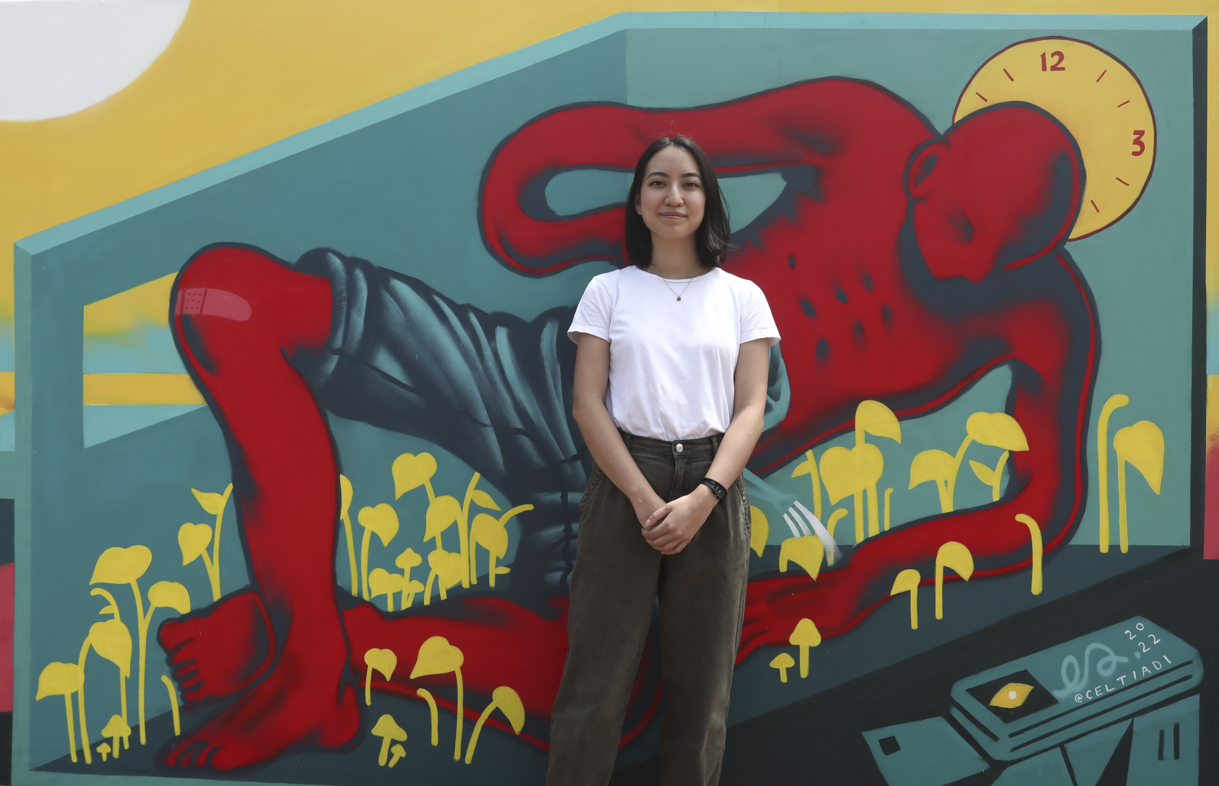 Celine Setiadi with her mural, outside the AIA Vitality Park at Central Pier. Photo: Jonathan Wong