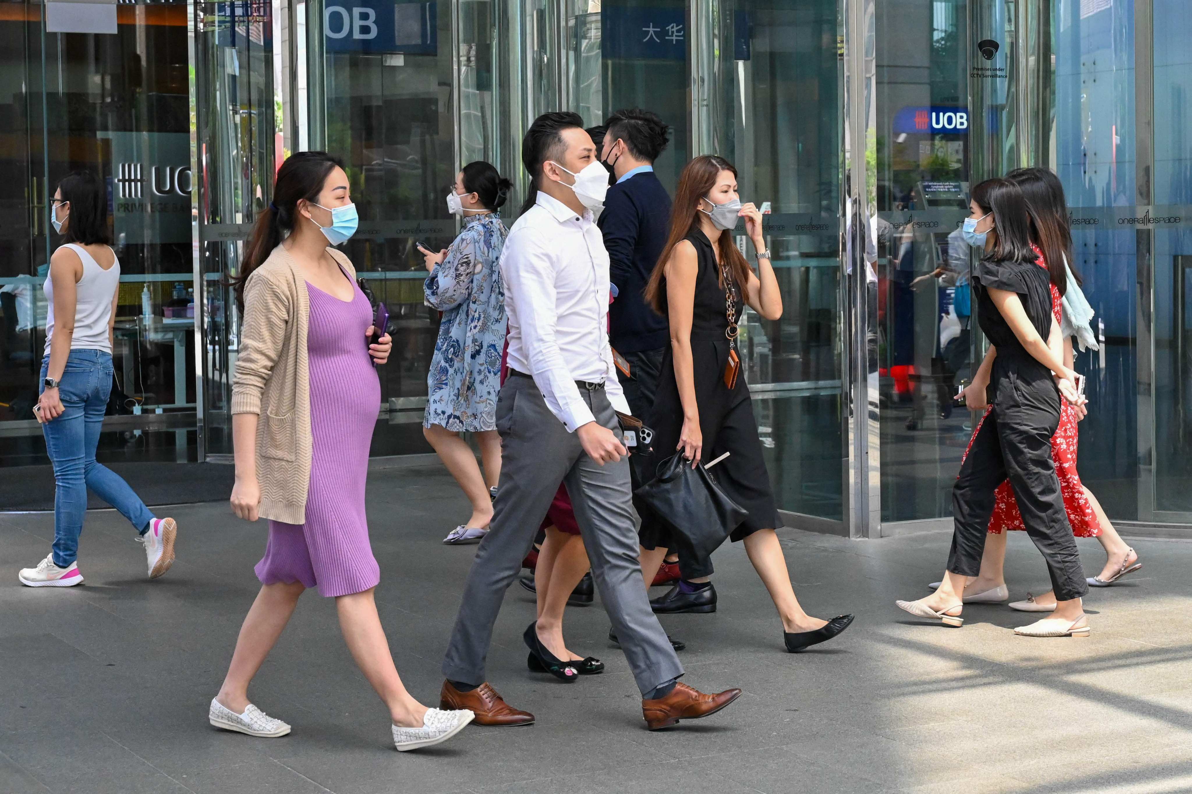 Office workers walk out for a lunch break in the financial business district in Singapore on May 10, 2022. ADDX claims its offering makes private equity more accessible to individual investors. Photo: Agence France Presse