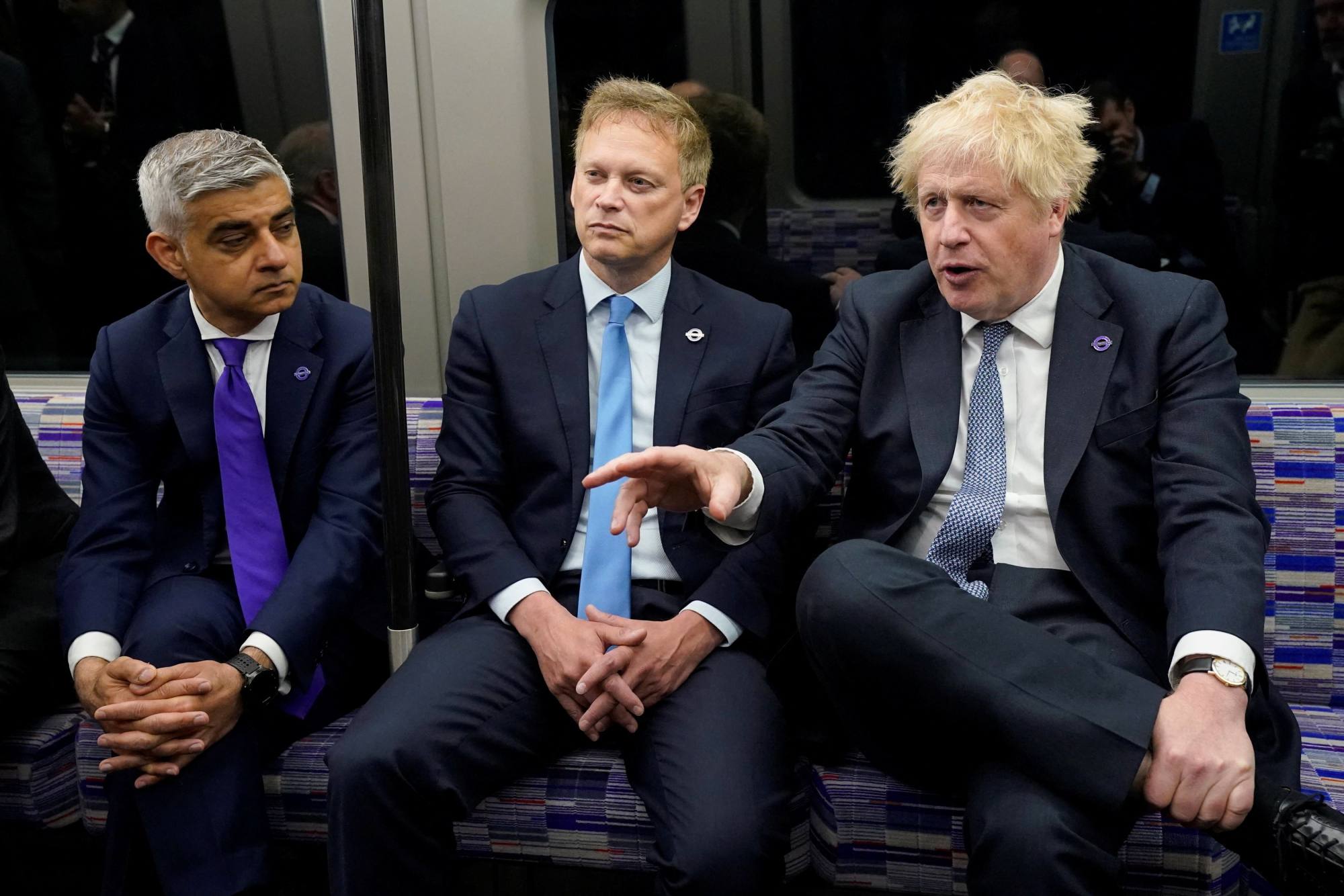 British Prime Minister Boris Johnson, right, sits on an Elizabeth Line train with London Mayor Sadiq Khan, left, and the UK’s transport minister. Photo: Reuters
