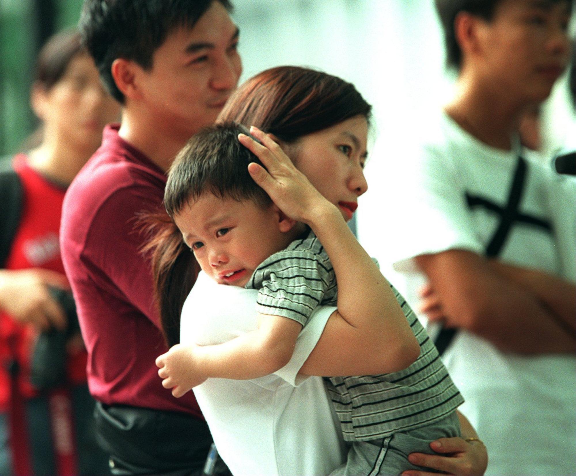 Wong Shuk-hing holds son Tsang Yau-hoi, three, as protesters waited in Wan Chai for the NPC’s ruling before marching to the Central Government Offices. Photo: David Wong