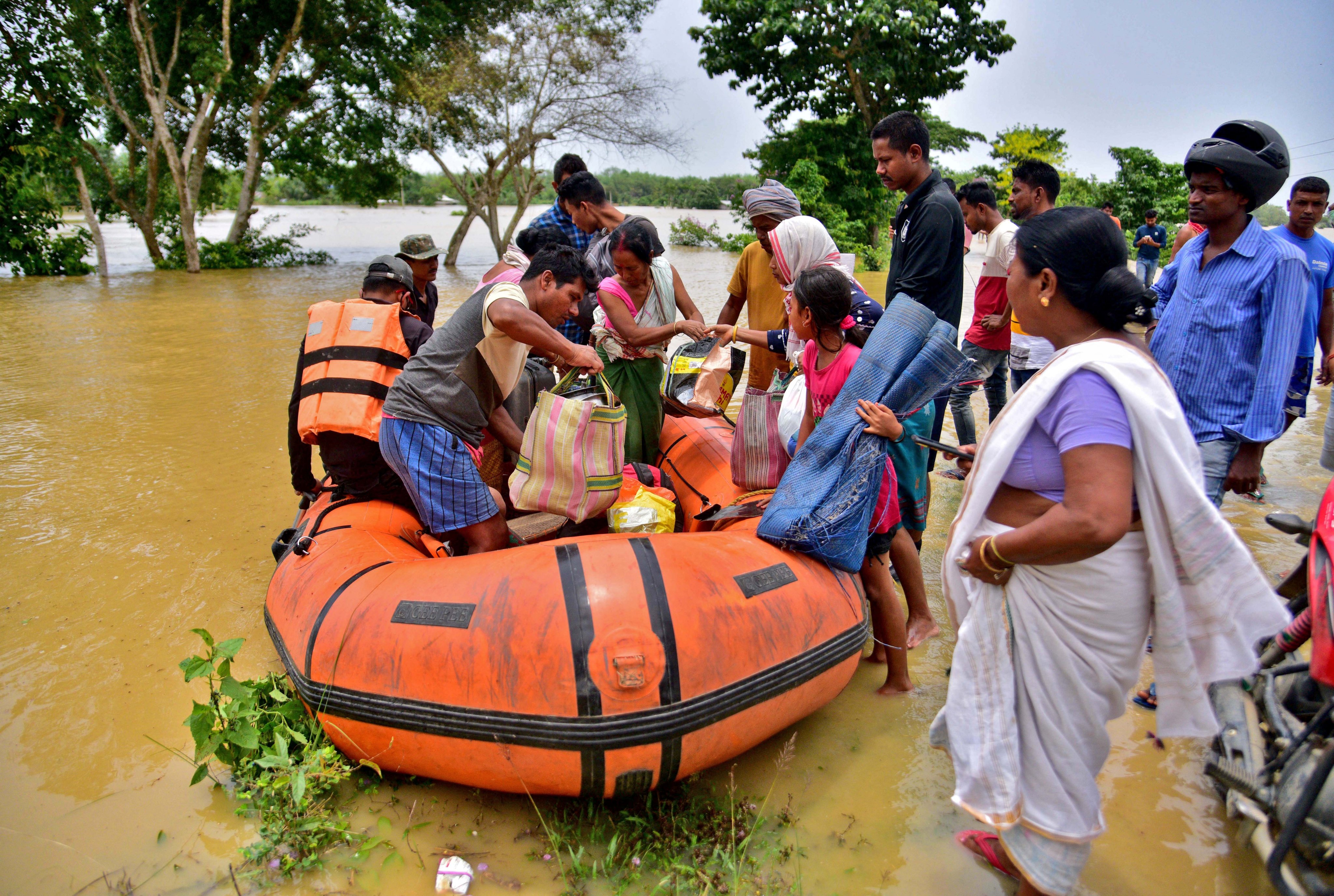 People disembark from a boat after being evacuated from a flooded village in Nagaon district in northeastern Assam state, India, on May 18. Photo: Reuters