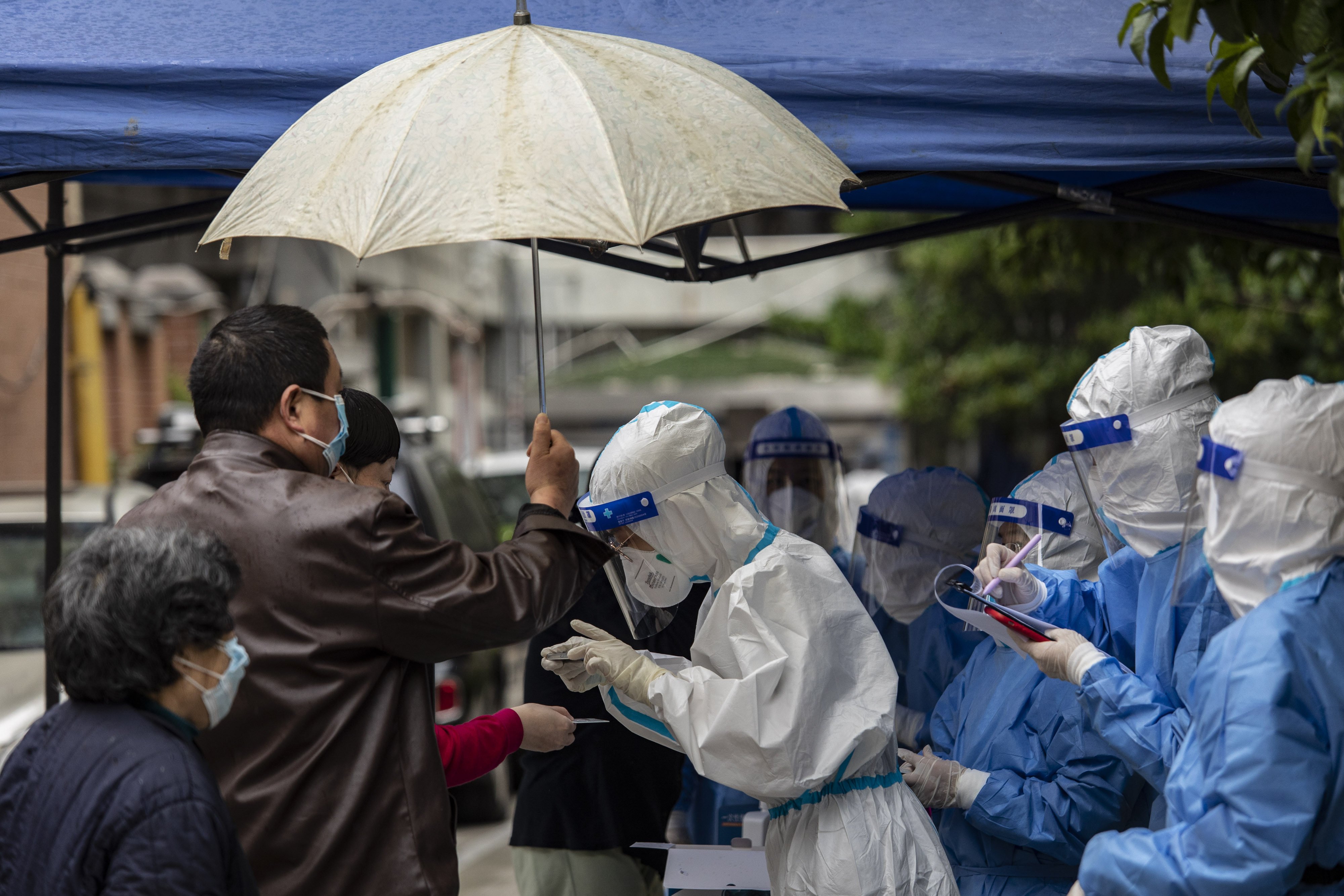 A team of health workers and volunteers check the identification of residents at a Covid-19 testing station in a neighbourhood where a suspected flare-up in cases occurred in Shanghai on May 9. Photo: Bloomberg