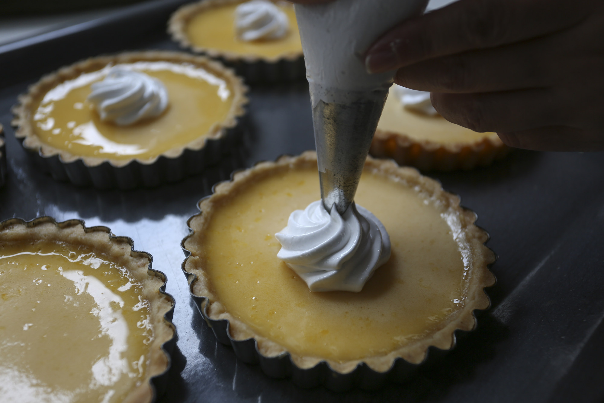 Pipe a rosette of meringue in the centre of each tart. Photo: Jonathan Wong