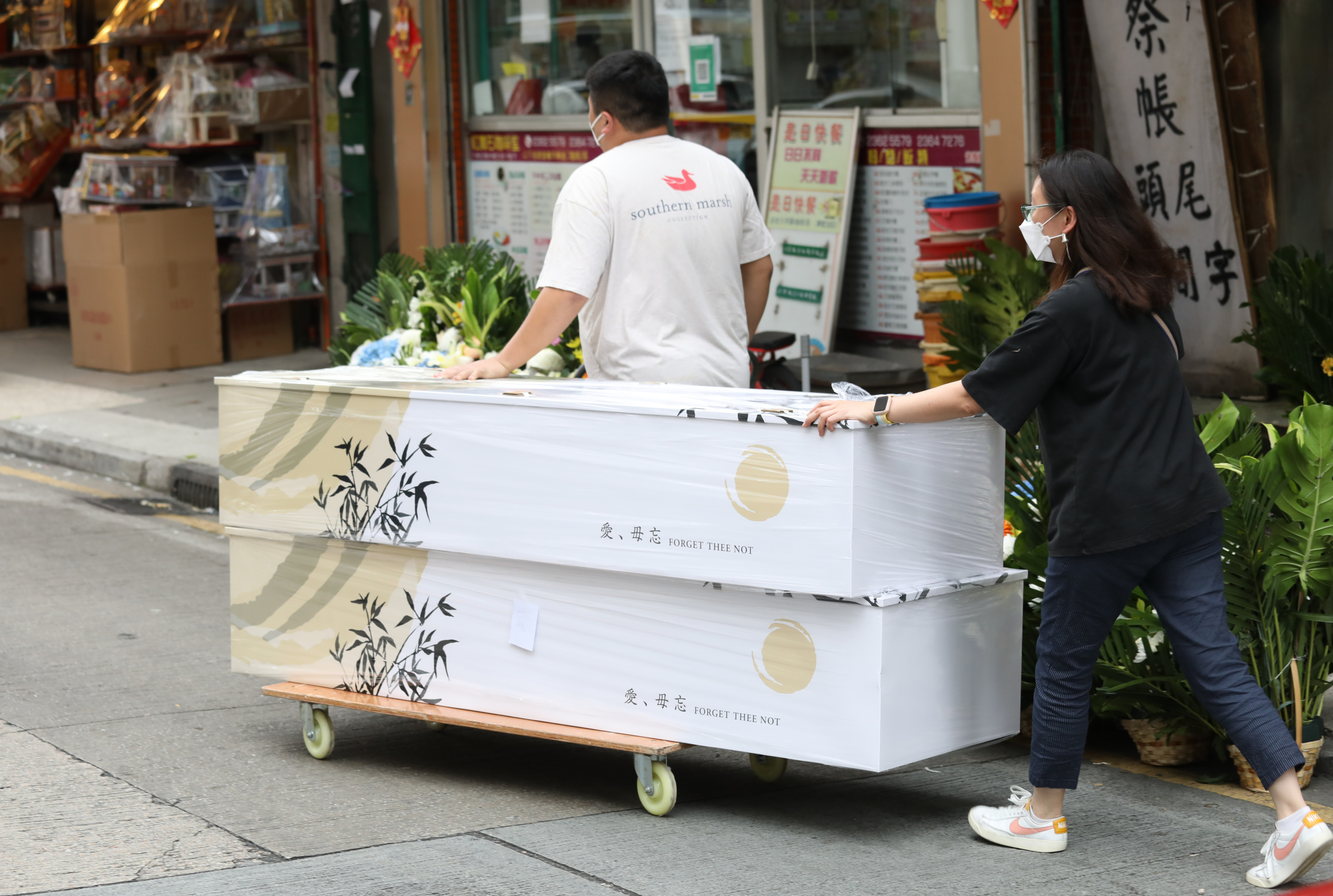 Workers transfer a coffin outside a funeral services shop in Hung Hom district in Hong Kong on March 16. Photo: Yik Yeung-man