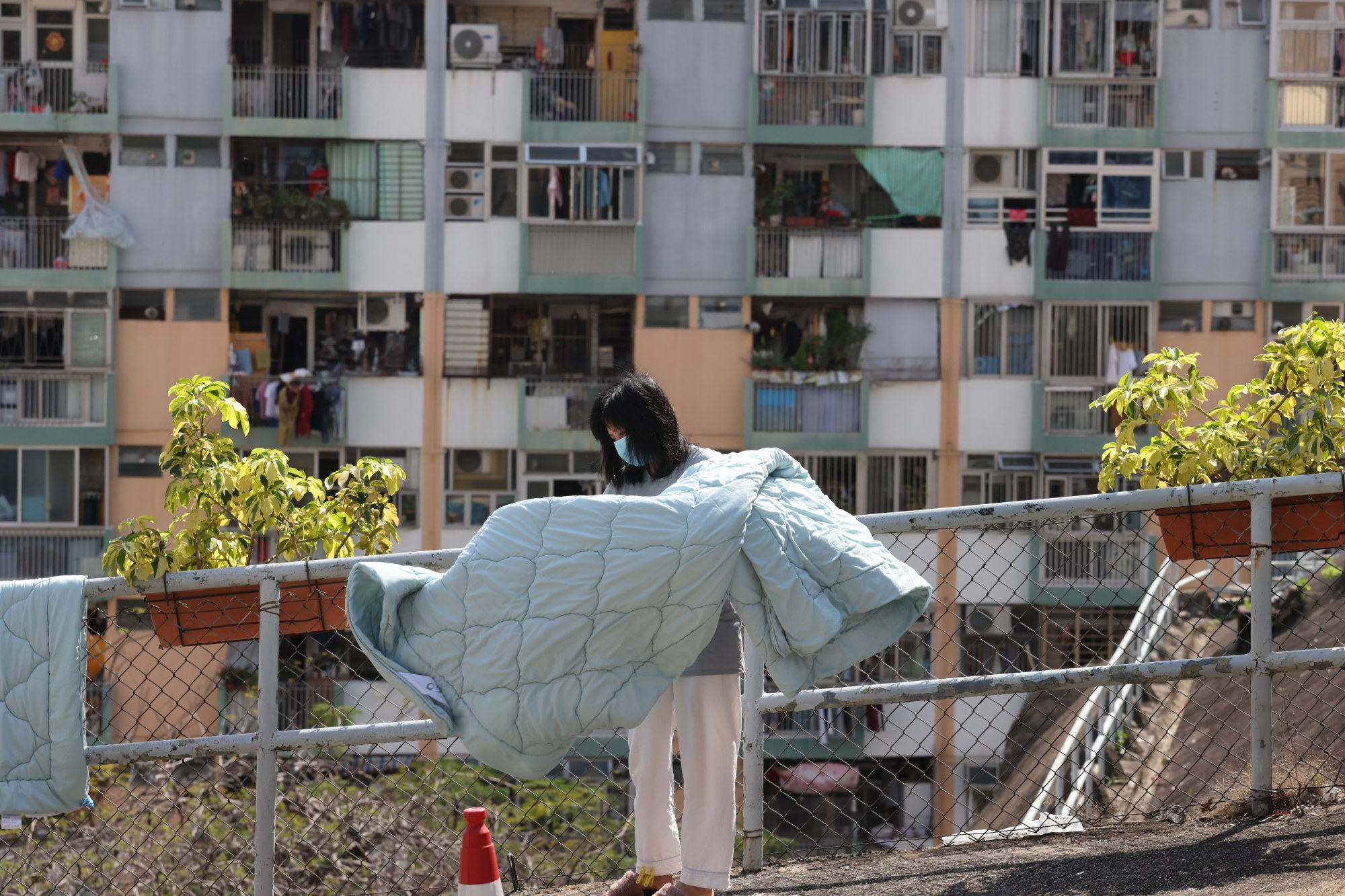 A woman dries laundry on April 11 in front of a public housing estate in Ngau Tau Kok which will be redeveloped in two phases. Photo: Nora Tam