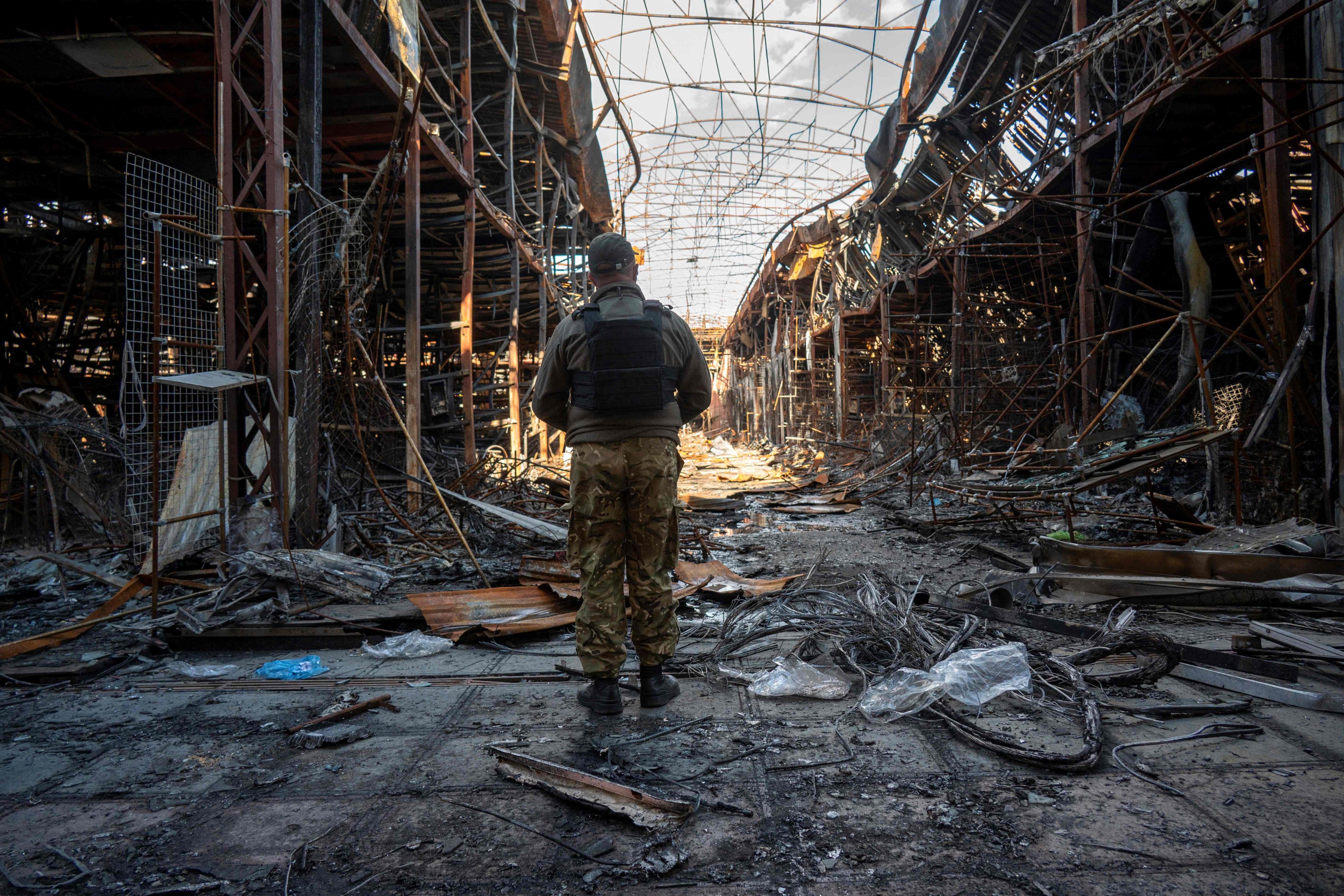 A Ukrainian police officer documents the destruction at one of Europe’s largest clothing markets, Barabashovo, in Kharkiv. Photo: AFP