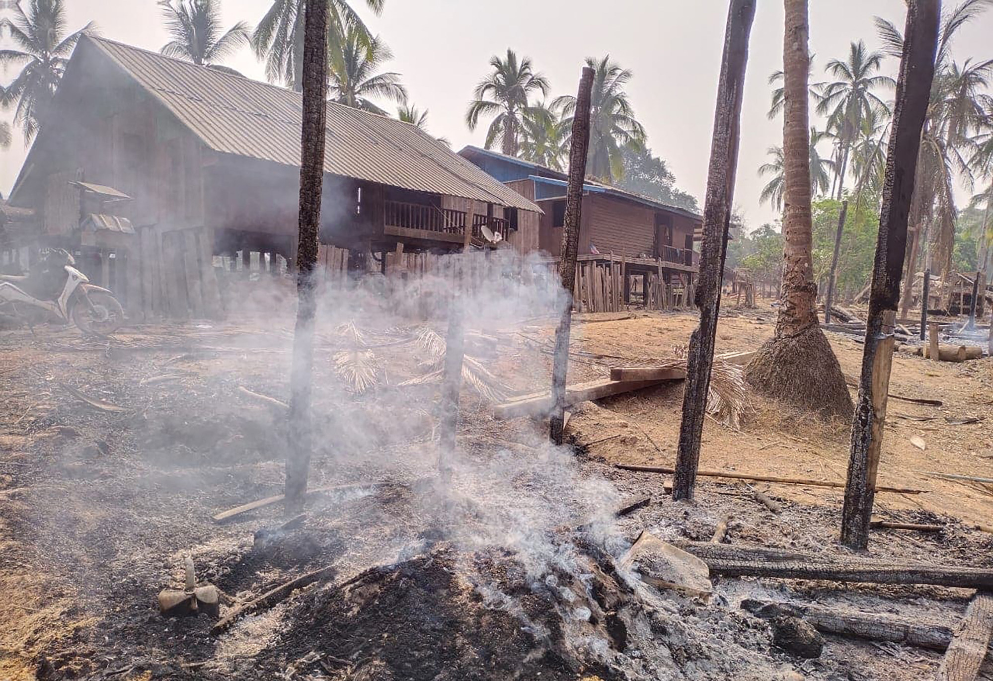 Smouldering ruins of a houses in a village in Hpa-pun in eastern Kayin state, after Myanmar military air strikes in April 2021. Photo: Handout / Kayin Information Centre/AFP